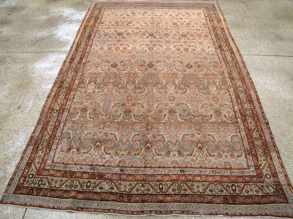 An antique Persian Malayer accent rug. This is a town Malayer, not a rural one, with a well- drawn allover Herati pattern on an abrashed oyster to graphite field with accents in dark brown, ivory, green and orange-red. The narrow main border is in