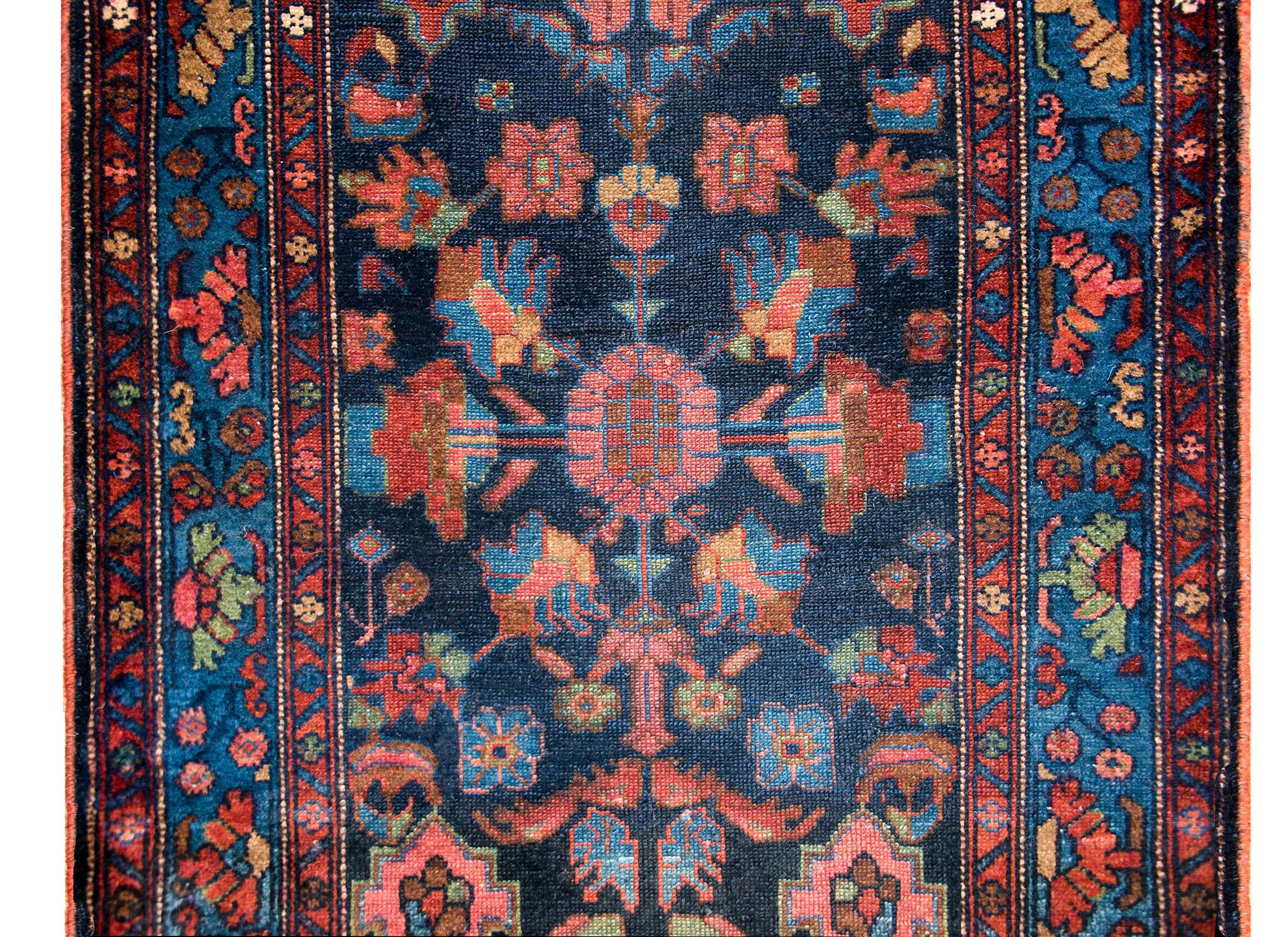 An incredible early 20th century Persian Malayer runner with an incredible mirrored all-over large and small scale floral pattern surrounded by a simple border with a central floral patterned stripe flanked by a pair of matching petite floral