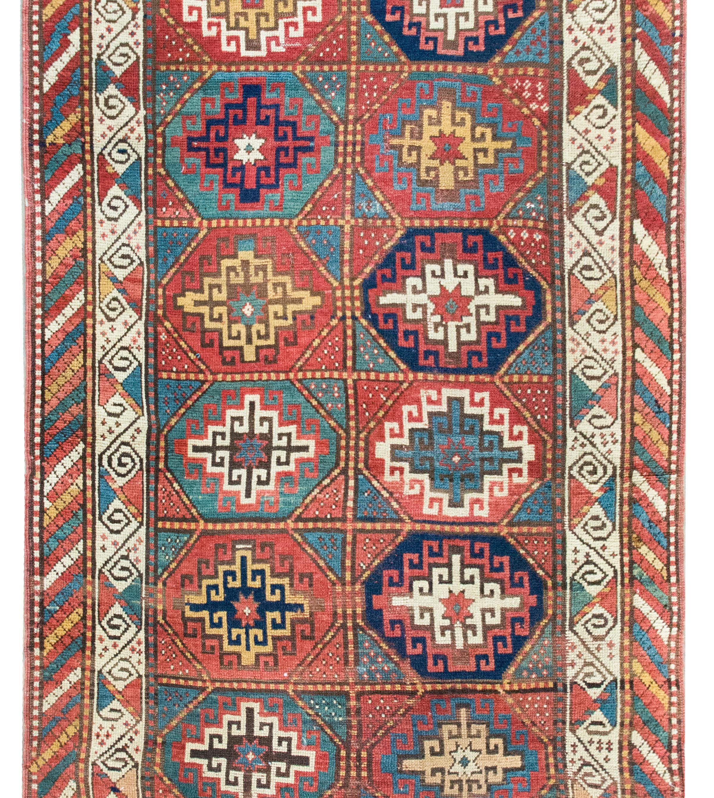 Uno splendido tappeto persiano Moghan dell'inizio del XX secolo con quattordici medaglioni geometrici a forma di diamante, ciascuno tessuto in varie tonalità di lana cremisi, indaco, verde, oro e bianco, e circondato da un incredibile bordo con