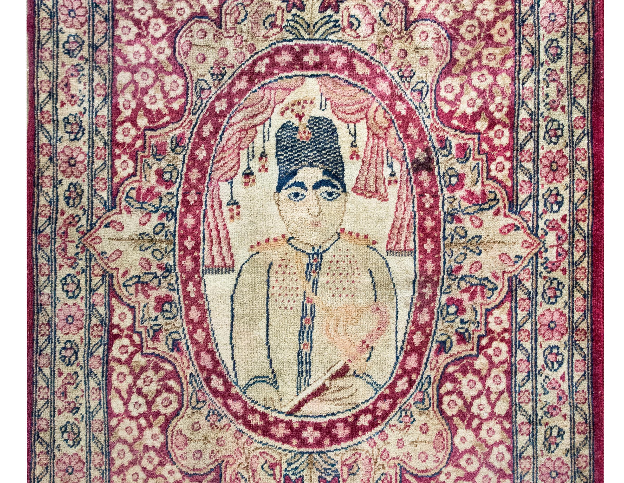 A wonderful early 20th century Persian Pictorial Lavar Kirman rug depicting a portrait of a gentleman in the center, framed by an elaborately woven border with triad flowers and vines, and all surrounded by a border with several petite floral and