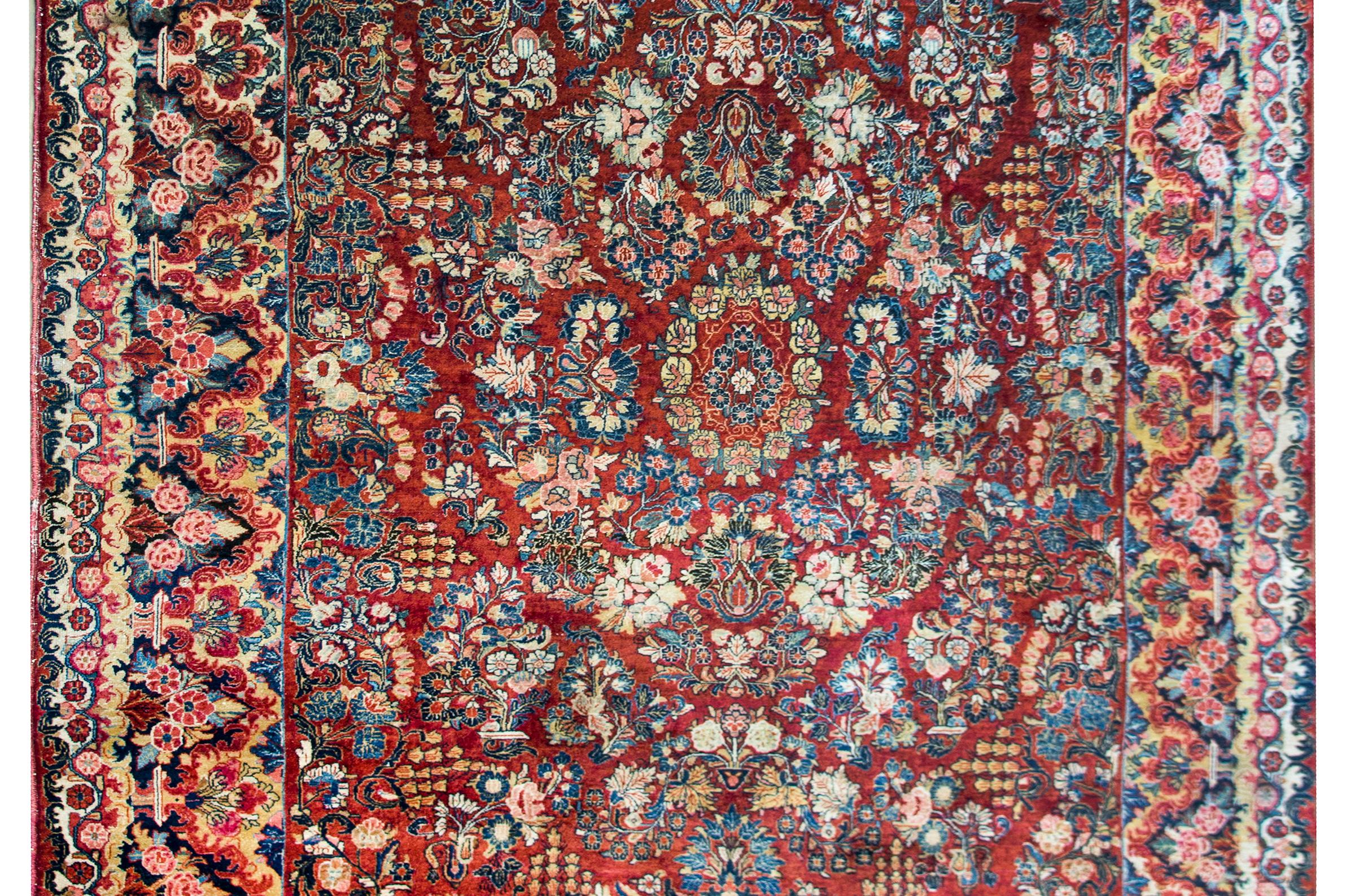 An incredible early 20th century Persian Sarouk rug with the most wonderful all--over floral cluster pattern covering the field, and surrounded by one of the most beautiful borders we've seen in a long time.