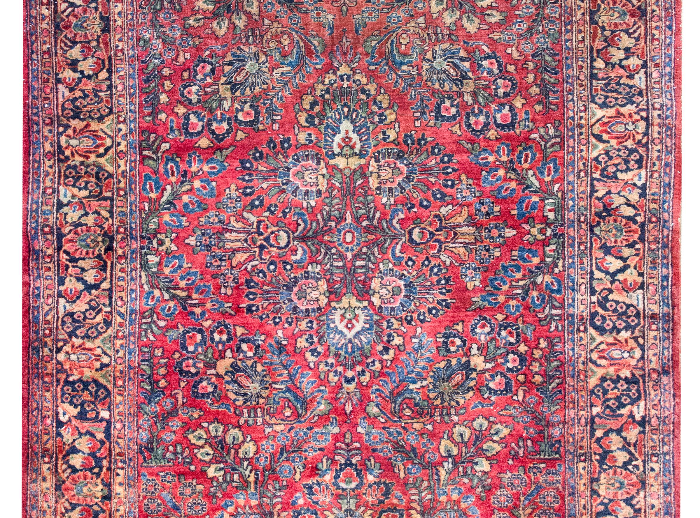 Questo tappeto Sarouk persiano dell'inizio del XX secolo è un classico esempio della raffinata eleganza floreale per cui i Sarouk sono famosi. Al centro si trova un grande medaglione centrale composto da fiori lussureggianti, circondato da gruppi