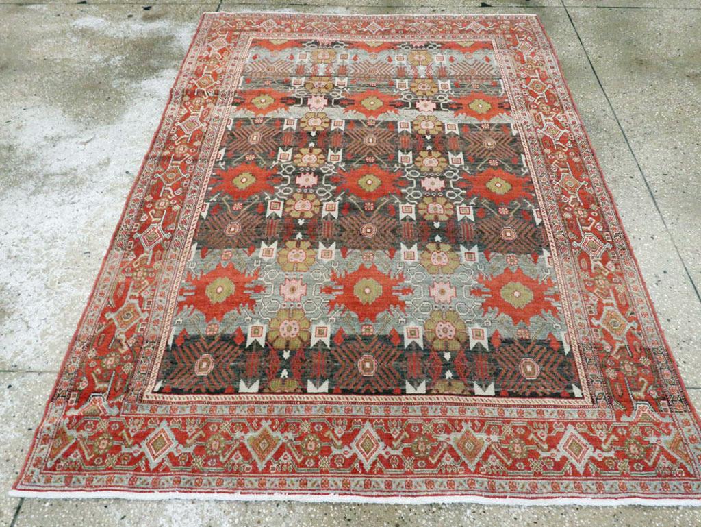 Un ancien tapis d'accent persan Senneh. Le champ d'ardoise résolument abrasé de ce tapis de ville kurde de l'ouest de la Perse présente un motif à grande échelle de trois colonnes de palmettes rayées et rouges unies, nettement différent du motif
