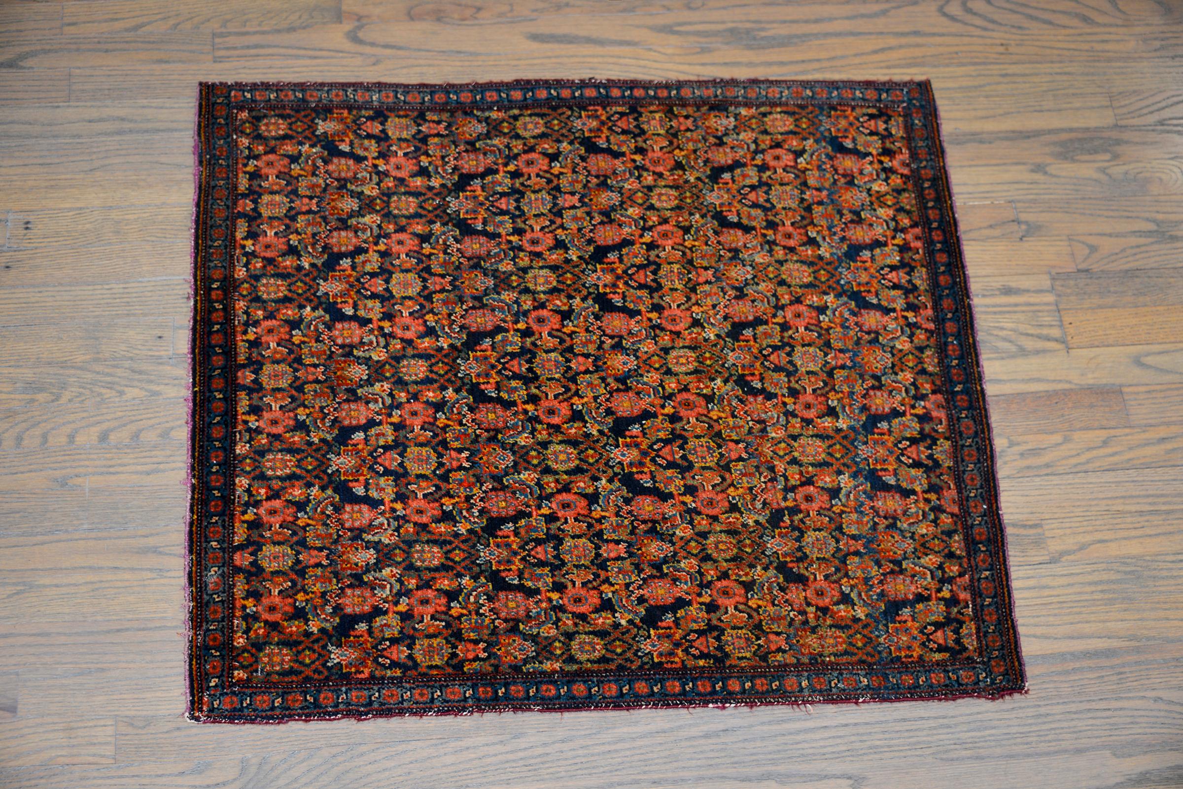 An incredible early 20th century Persian Senneh rug with an all-over trellis floral pattern woven in myriad colors including crimson, gold, green, light indigo, and pink, and set against a dark indigo background.