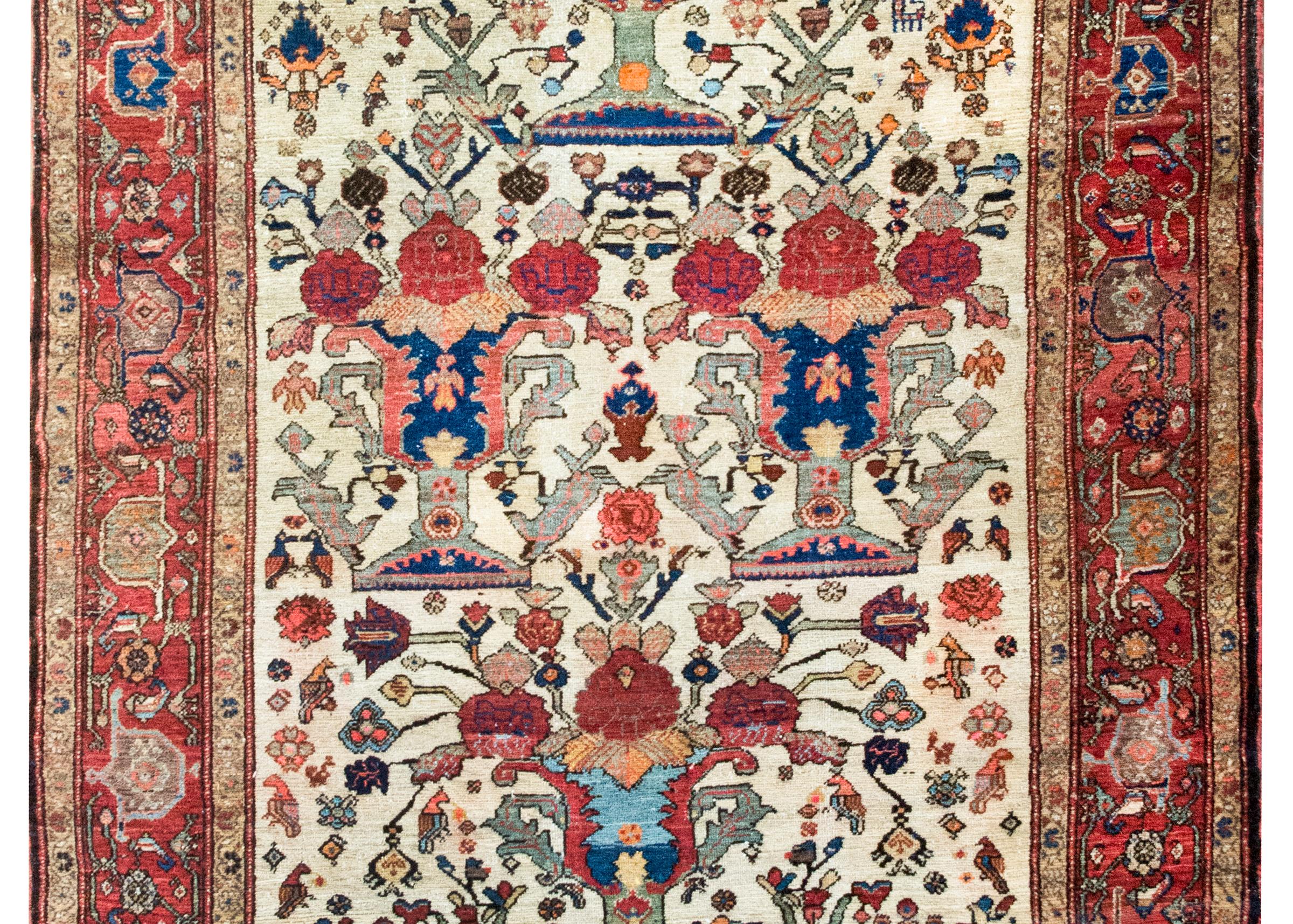 Uno straordinario tappeto persiano Senneh dei primi del Novecento, risalente al 1900 circa, annodato a mano in lana pregiata e caratterizzato da una suggestiva composizione di quattro grandi alberi della vita. Ogni albero si erge da un vaso