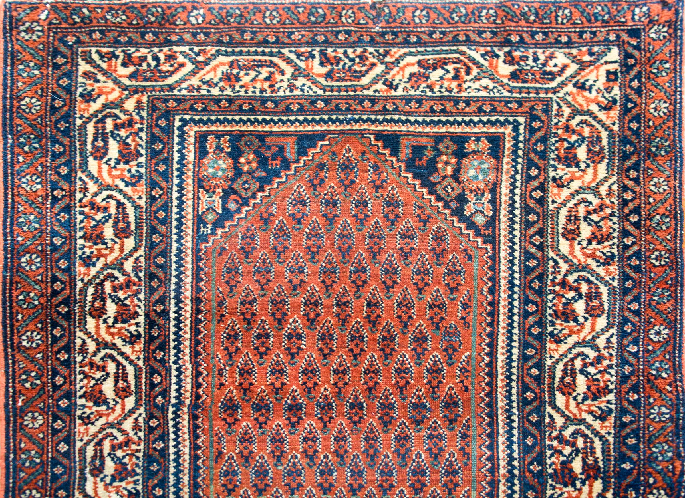 A wonderful early 20th century Persian Seraband runner with an all-over paisley patterned field against a crimson background, and surrounded by a border composed of multiple petite floral patterned stripes.
