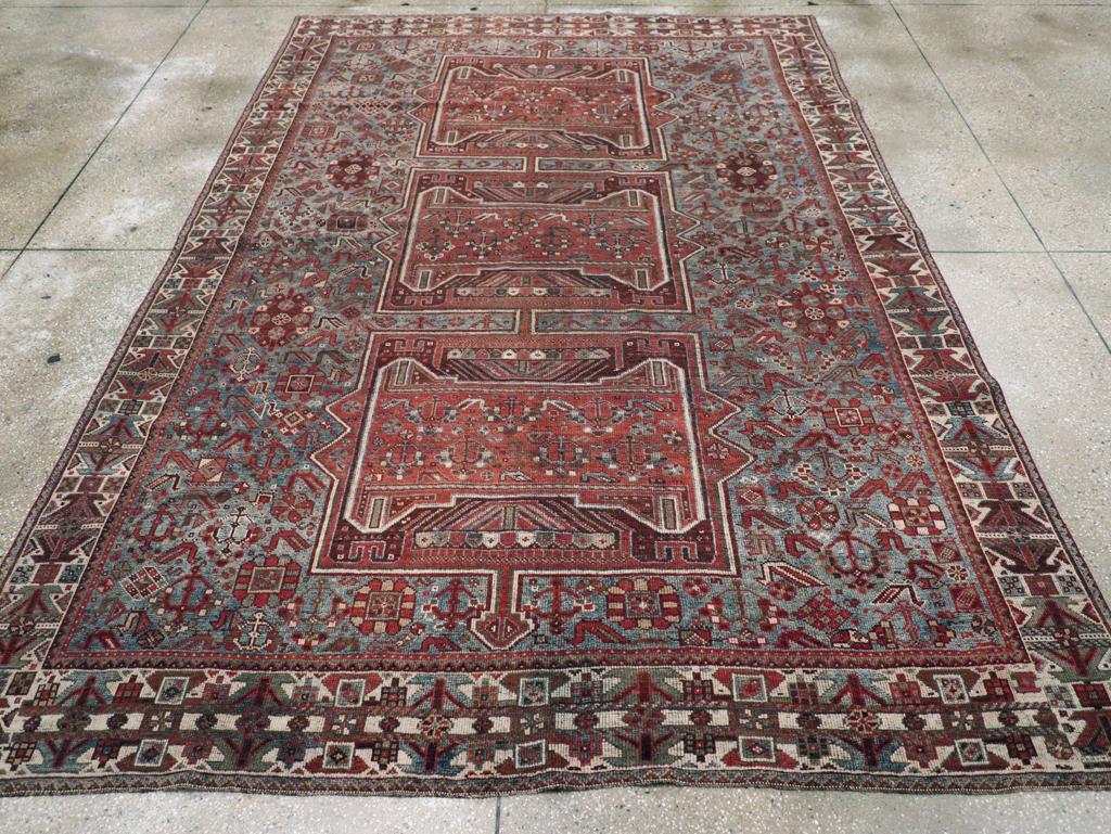 A Wool pile in asymmetric knots on a wool foundation. The light blue ground features the characteristic Khamseh tribal peacocks, set against a tripartite red pole medallion composed of squares, each enclosing a partially concave red panel with more