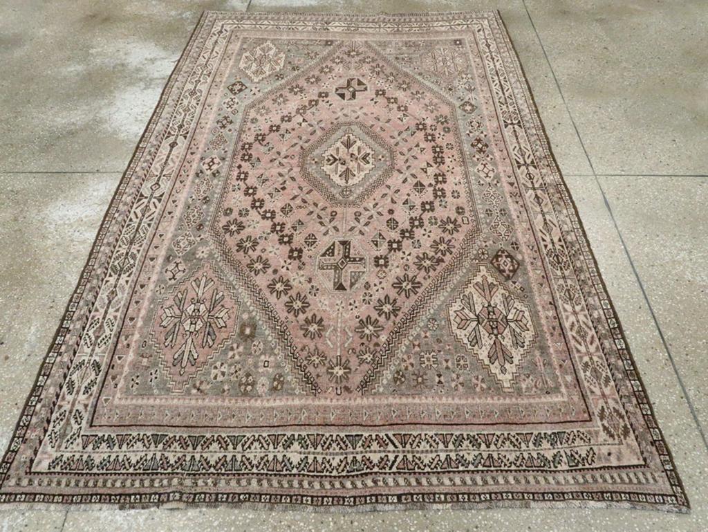 An antique Persian Shiraz accent rug. Either Khamseh or Qashghai, the two main tribal groups situated around Shiraz city in southern Persia, this large scatter features a graphite field with large hexagonal corner motives enclosing a tall, stretched