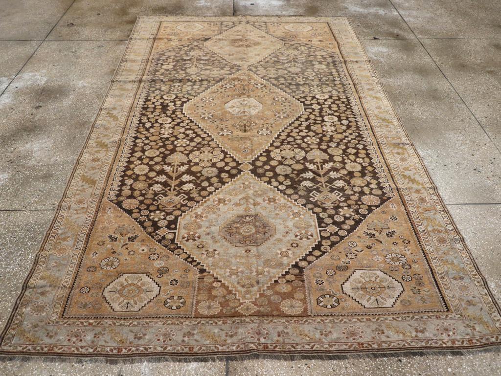 An antique Persian Shiraz accent rug. This generically ‘Shiraz’. South Persian surely, this all wool nomadic rug has a dark blue subfield centered by a red and celadon pole medallion of three joined minutely stepped hexagons, all surrounded by a