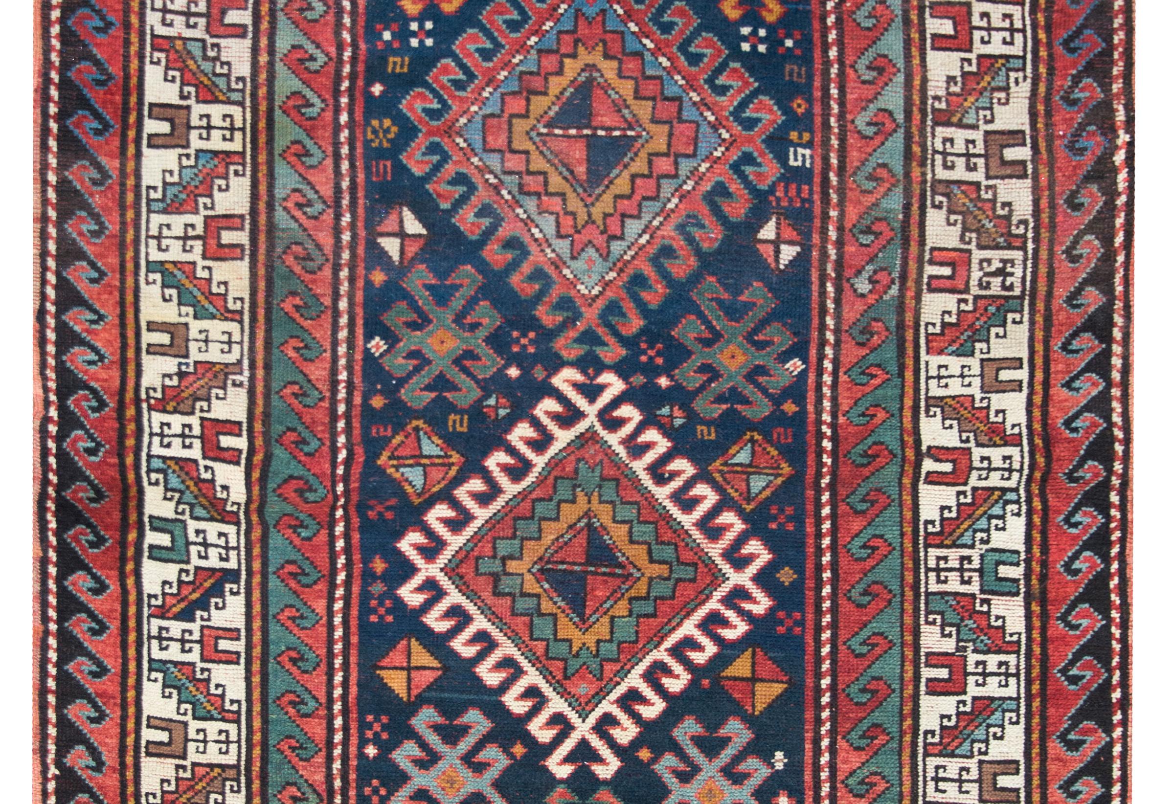 A stunning early 20th century Persian Shriven rug with three large stylized floral diamond medallions living amidst a field of more stylized flowers, and surrounded by an incredible border of even more stylized leaves and geometric patterns, and all