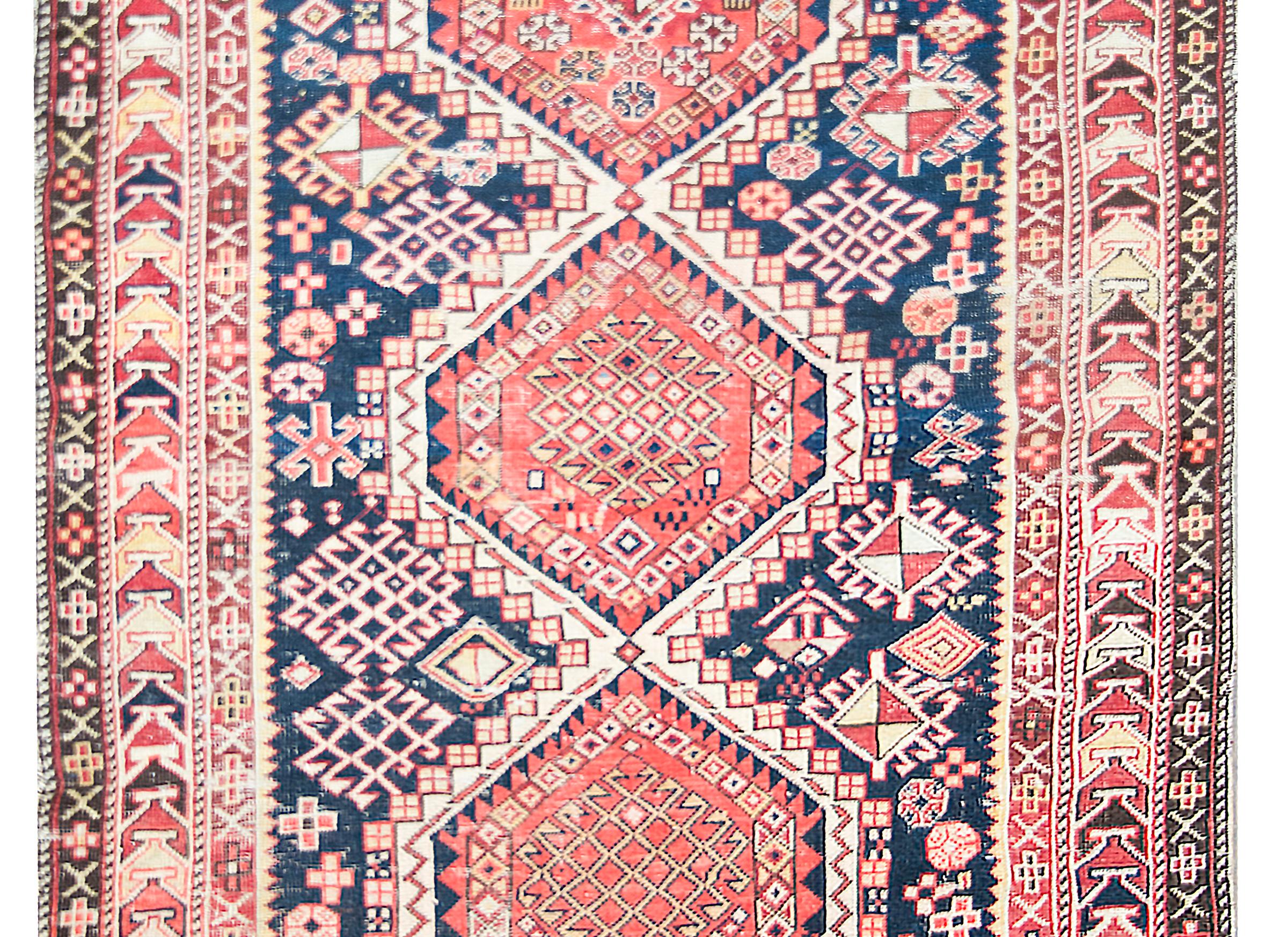 An exciting early 20th century Persian Shrivan rug with three large central diamond medallions  with myriad stylized floral patterns, living amidst a field of even more stylized flowers, and surrounded by the most beautiful border composed of three