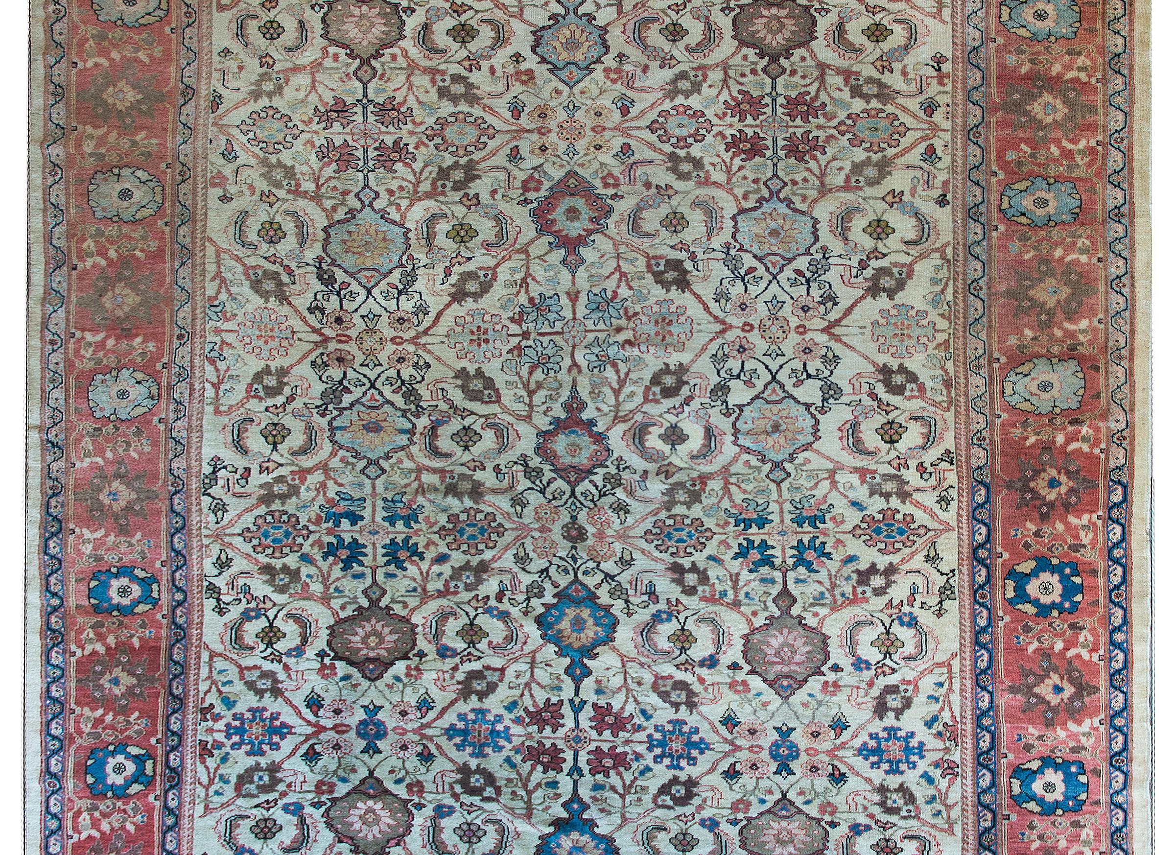 A fabulous early 20th century Persian Sultanabad rug with an overall repeated and mirrored floral and scrolling vine pattern, surrounded by a wide repeated floral patterned central stripe, and flanked by wonderful petite scrolling vine patterned