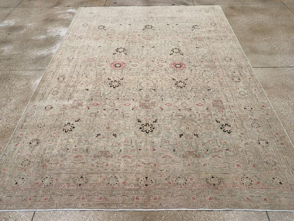 A wool pile of symmetric knots on a cotton foundation. As is typical of Tabriz carpets, this well-balanced piece features a powder-grey field with round rosettes, octofoils, and wiry right angles, subtly accented in deep brown. The continuous