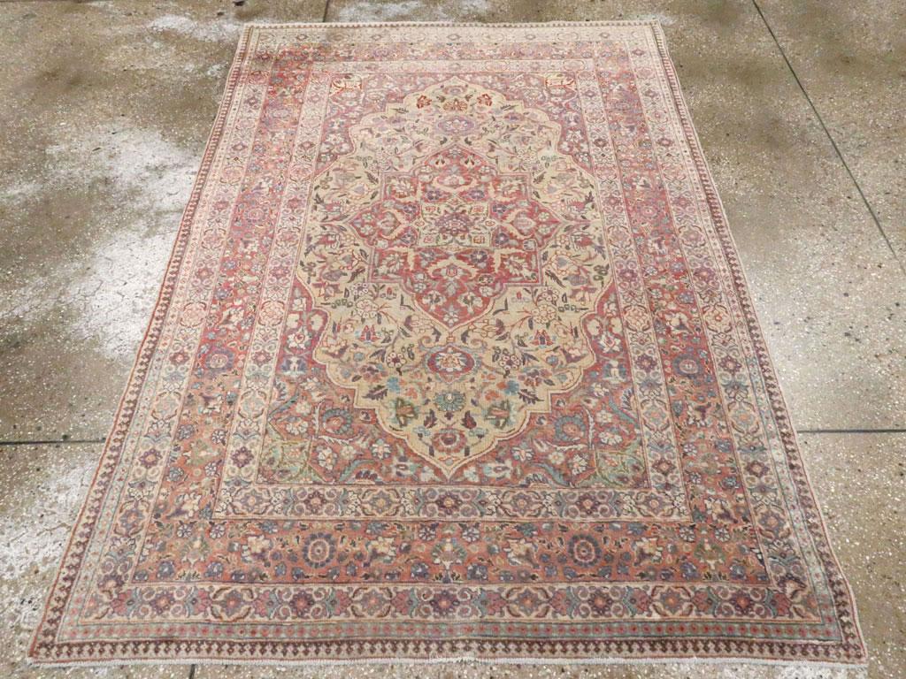Ein antiker persischer Täbriz-Akzentteppich. Ein braunes, blumengefülltes Oktogramm mit Hängemedaillon zentriert das blassgelbe Feld mit seinen fast spiralförmigen Arabesken, Blättern und kleinen Blüten.  Die großen Ecken verleihen dem Ganzen ein
