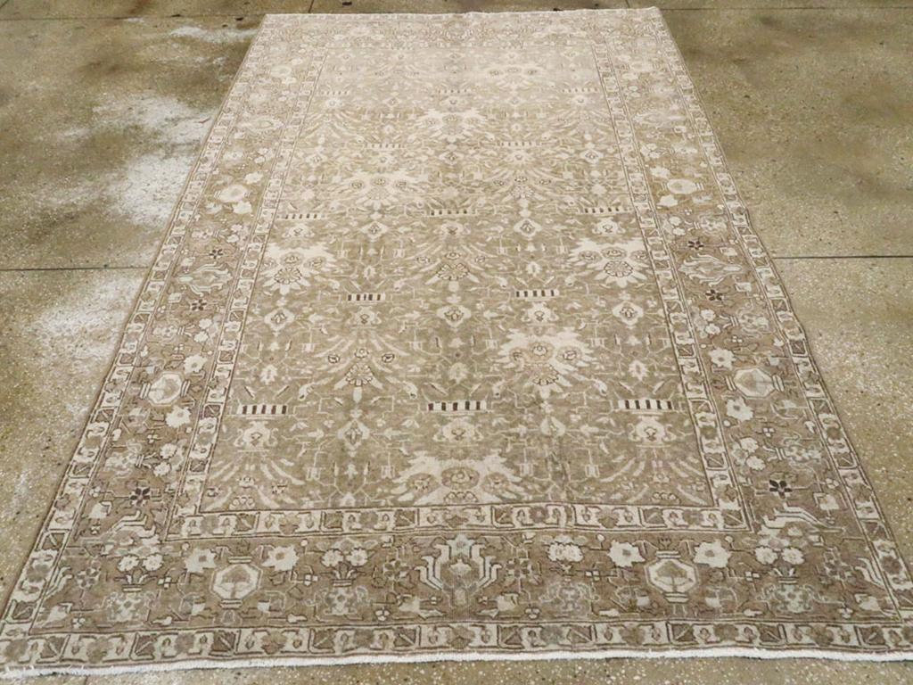 Un antico tappeto d'accento persiano Tabriz. Questo tappeto da città persiano di NW, fondamentalmente bicolore marrone e beige, presenta un motivo unidirezionale a cinque colonne sfalsate, con palmette vigorose ed eccentriche e piccoli vasi su