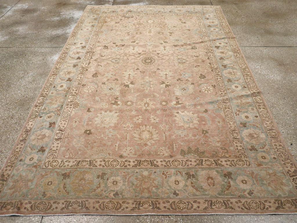 Un vello di lana con nodi simmetrici su una base di cotone. Una rosetta multi-petalo è incastonata in un diamante centrale, sostenuto da palmette laterali a forma di pigro petalo. Il campo di color ambra tenue è caratterizzato da palmette, viti