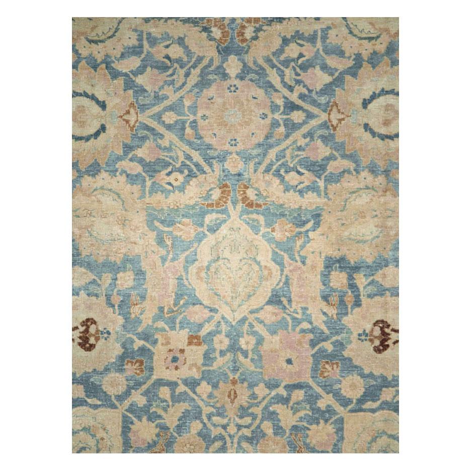 An antique Persian Tabriz room size carpet handmade during the early 20th century with a greyish blue field and cream border.

Measures: 9' 0