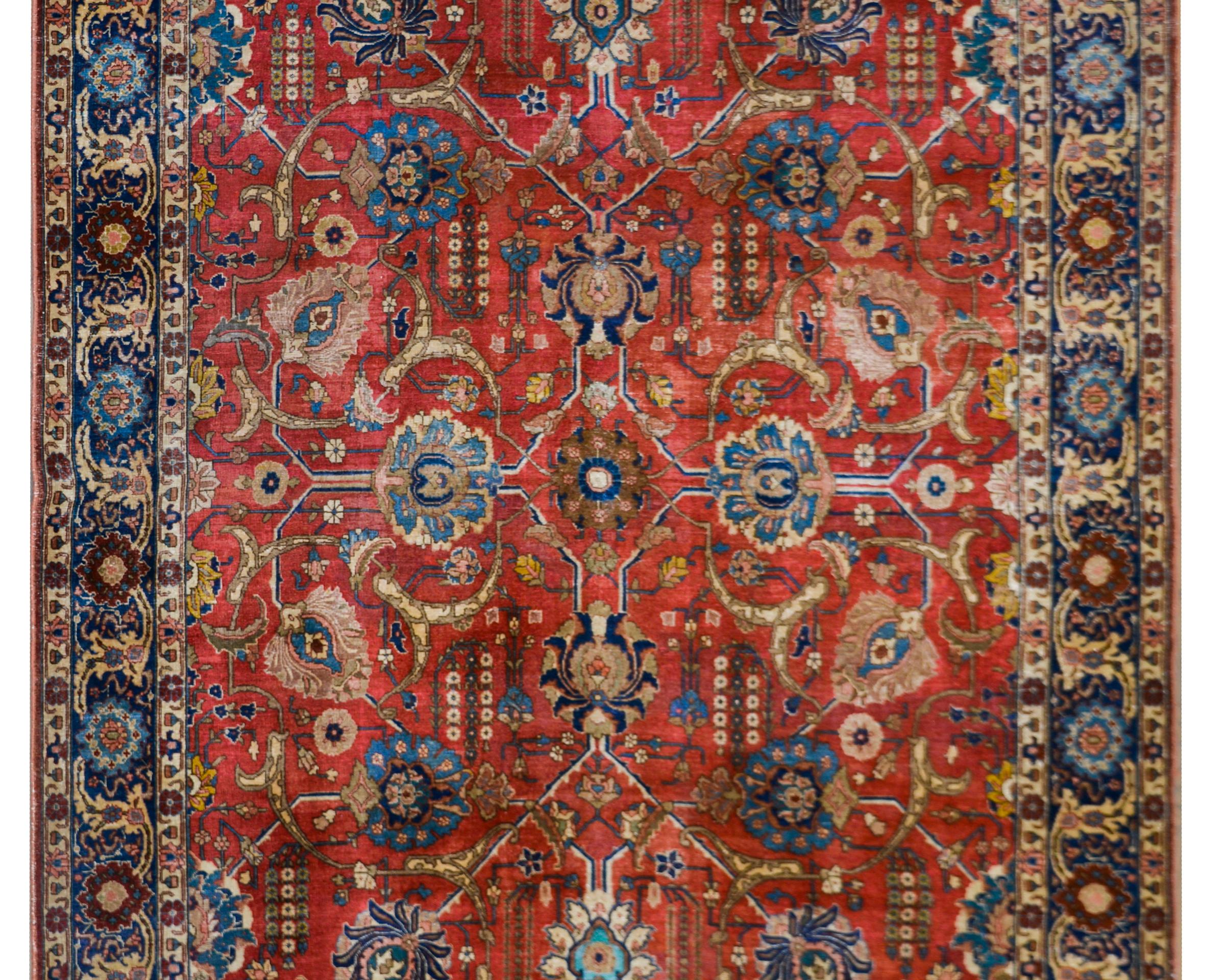 Outstanding early 20th century Persian Tabriz rug with an all-over large-scale mirror floral trellis pattern woven in beautiful rich jewel-tone colors including set against a beautiful crimson background. The border is beautiful with a wide floral