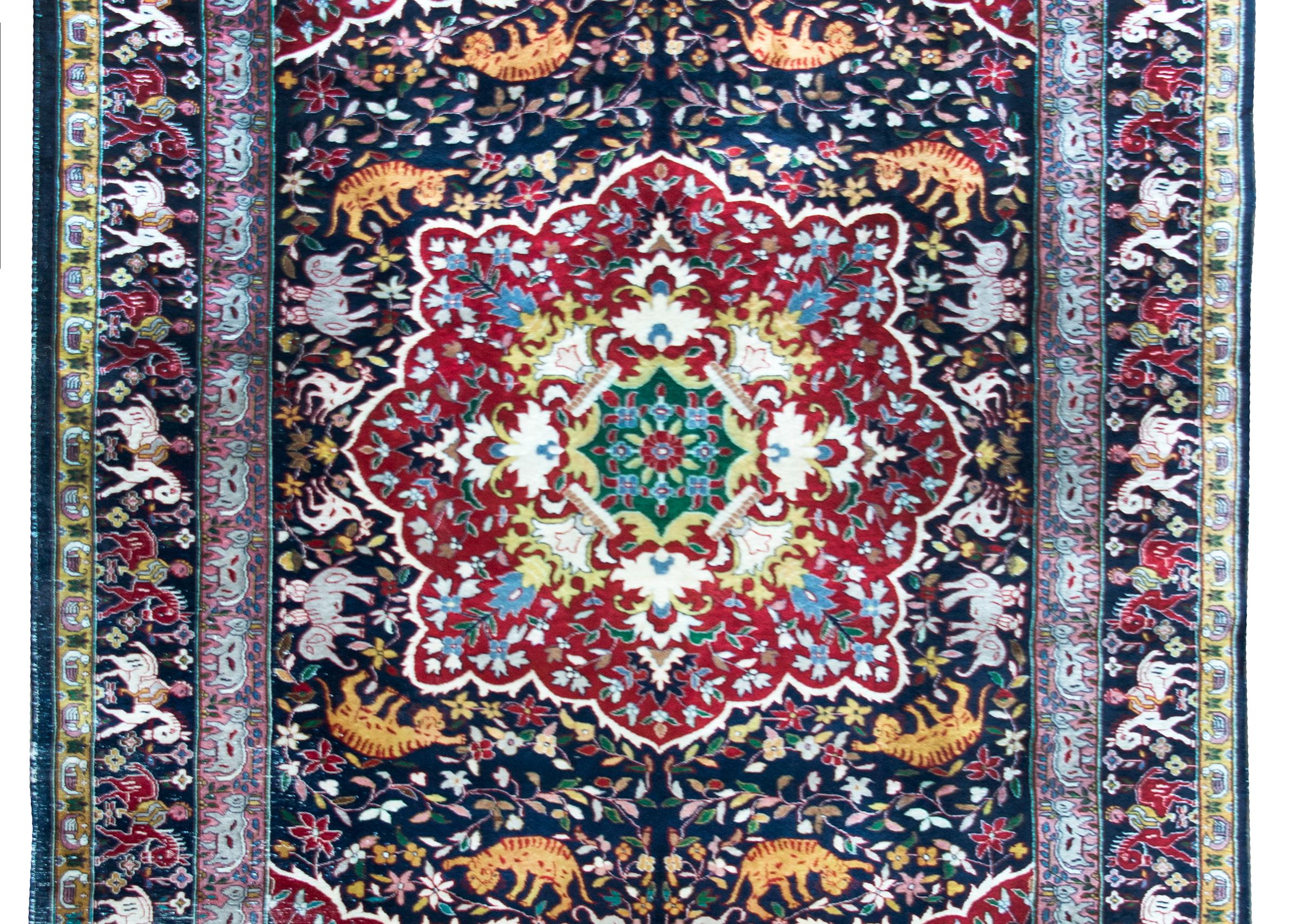 Un raro e affascinante tappeto persiano Tabriz dell'inizio del XX secolo con un motivo a specchio con una miriade di animali, tra cui elefanti, tigri, cervi, cavalli e bufali d'acqua, che vivono in mezzo a una foresta fittamente intrecciata con