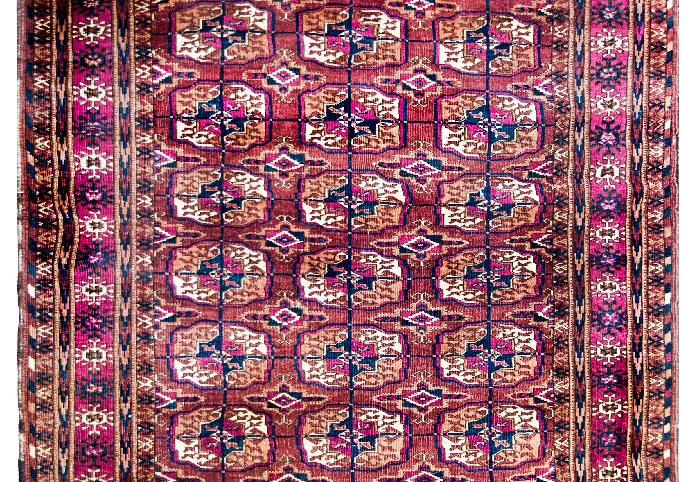 A beautiful early 20th century Persian Tech rug with an all-over pattern with myriad medallions with stylized flowers and leaves, surrounded by a complex border of myriad stylized flower and geometric patterned stripes, and all woven in indigo,