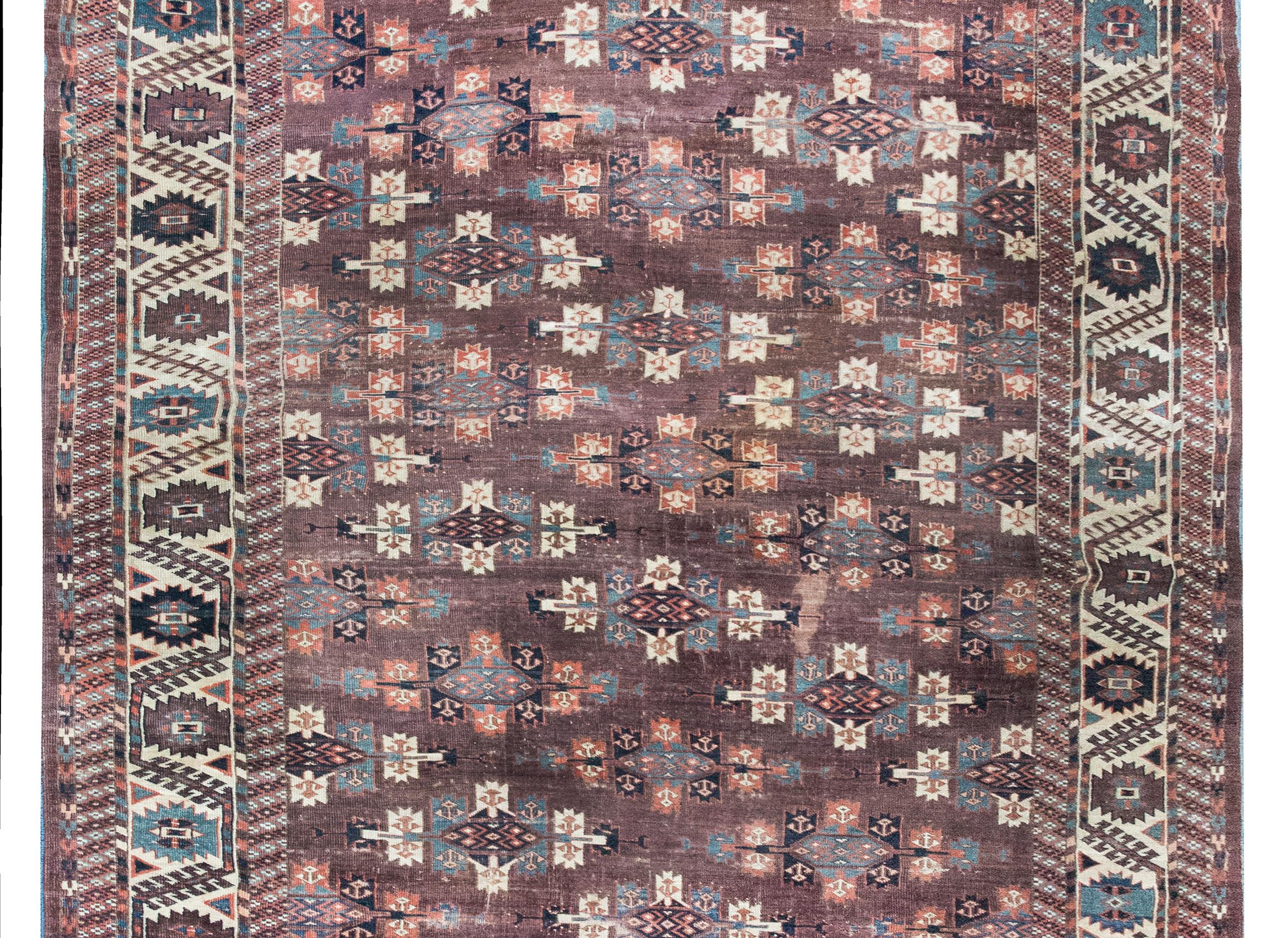Un meraviglioso tappeto persiano turkmeno dell'inizio del XX secolo con una miriade di medaglioni in tutto il campo, circondati da un bordo stilizzato e stilizzato a forma di fiore e vite che è affiancato da strisce geometriche più piccole. 