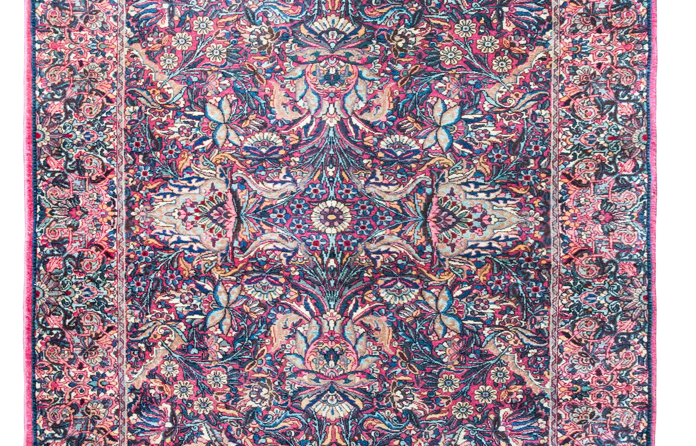 Uno splendido tappeto persiano Yazd dell'inizio del XX secolo con un incredibile motivo a trama fitta che comprende un grande medaglione floreale centrale a specchio circondato da fiori, viti e foglie a trama ancora più fitta, il tutto circondato da