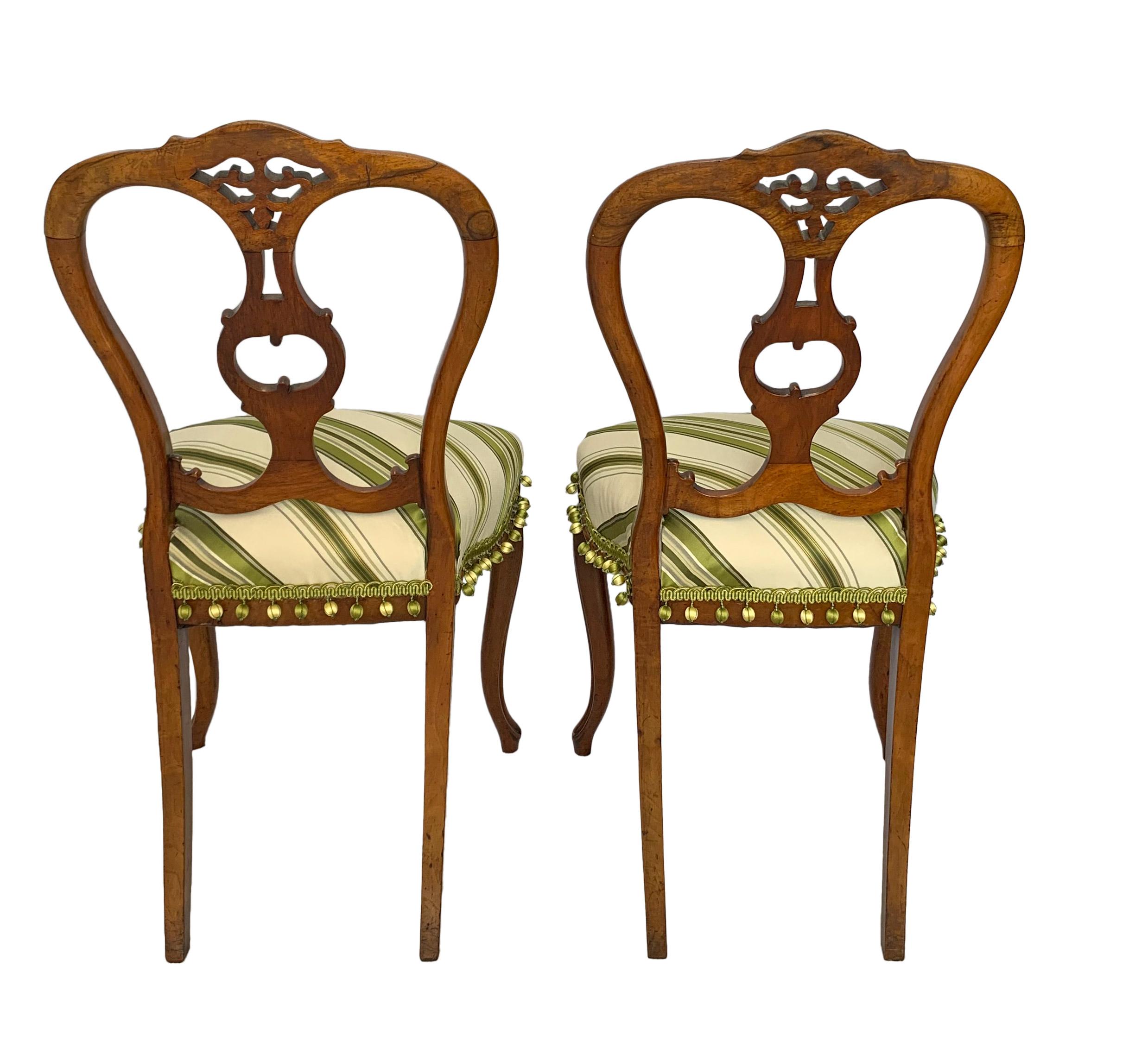 Early 20th century Petite Victorian style elegantly sculpted balloon back chairs. This modern take on the Victorian balloon back side chair which traditionally has smaller seats to accommodate the ladies’ massive skirt bustle is perfect for a more