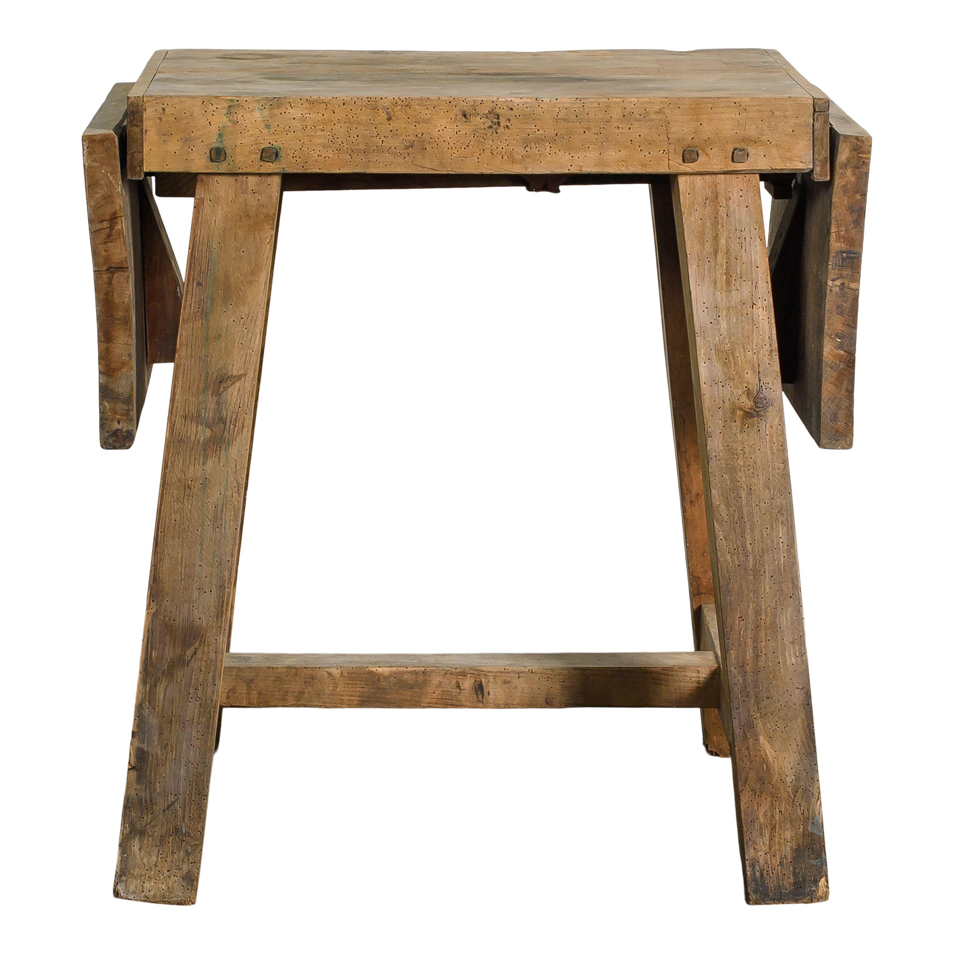 A small drop-leaf wood side table imported from France and made in the early 20th century. This table has two folding leaves that take the table from 29 inches wide when folded down and 49.25 inches wide folded up. The folding mechanism is all wood