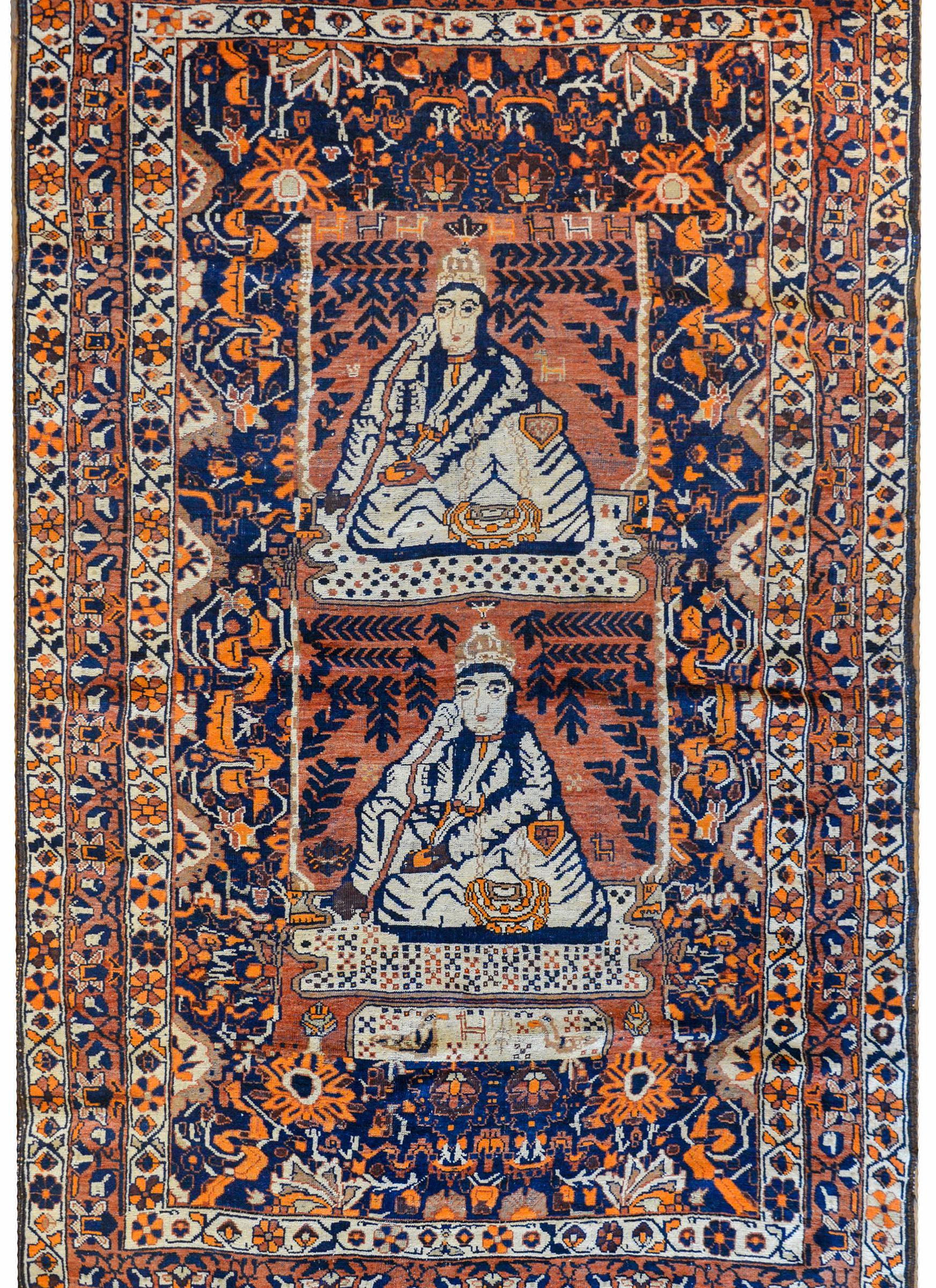 A wonderful early 20th century Persian pictorial Qashgai rug depicting a seated figure, twice, in front of a pond with ducks and chickens, amidst a lush oasis of willow trees and a field or beautifully rendered flowers, all woven in indigo, orange,