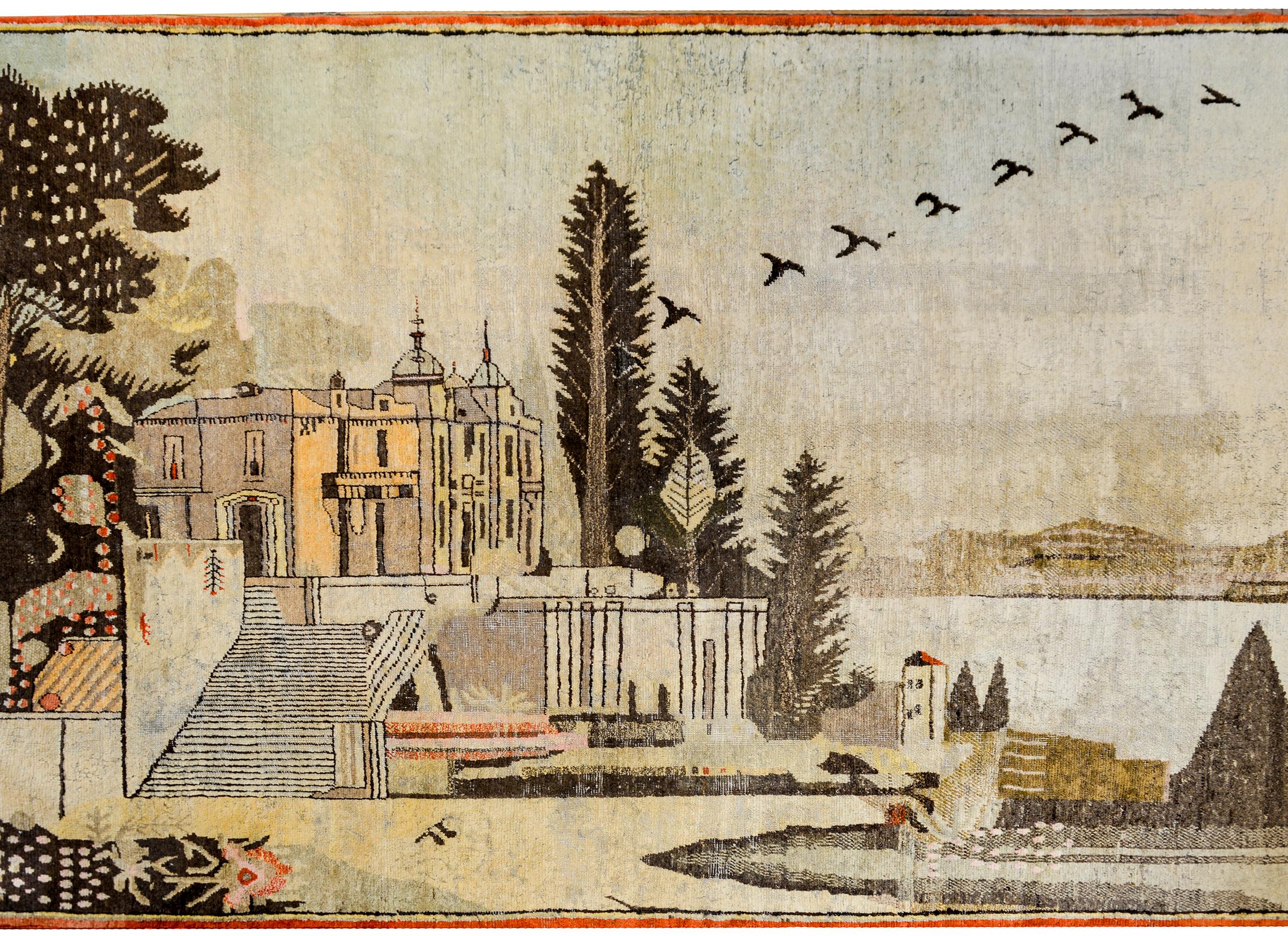 A fantastic early 20th century Central Asian pictorial Yargkand rug depicting a building sitting on a hill overlooking a lake. A grande staircase leads to a garden with trees and flowers, while a flock of birds flies past.