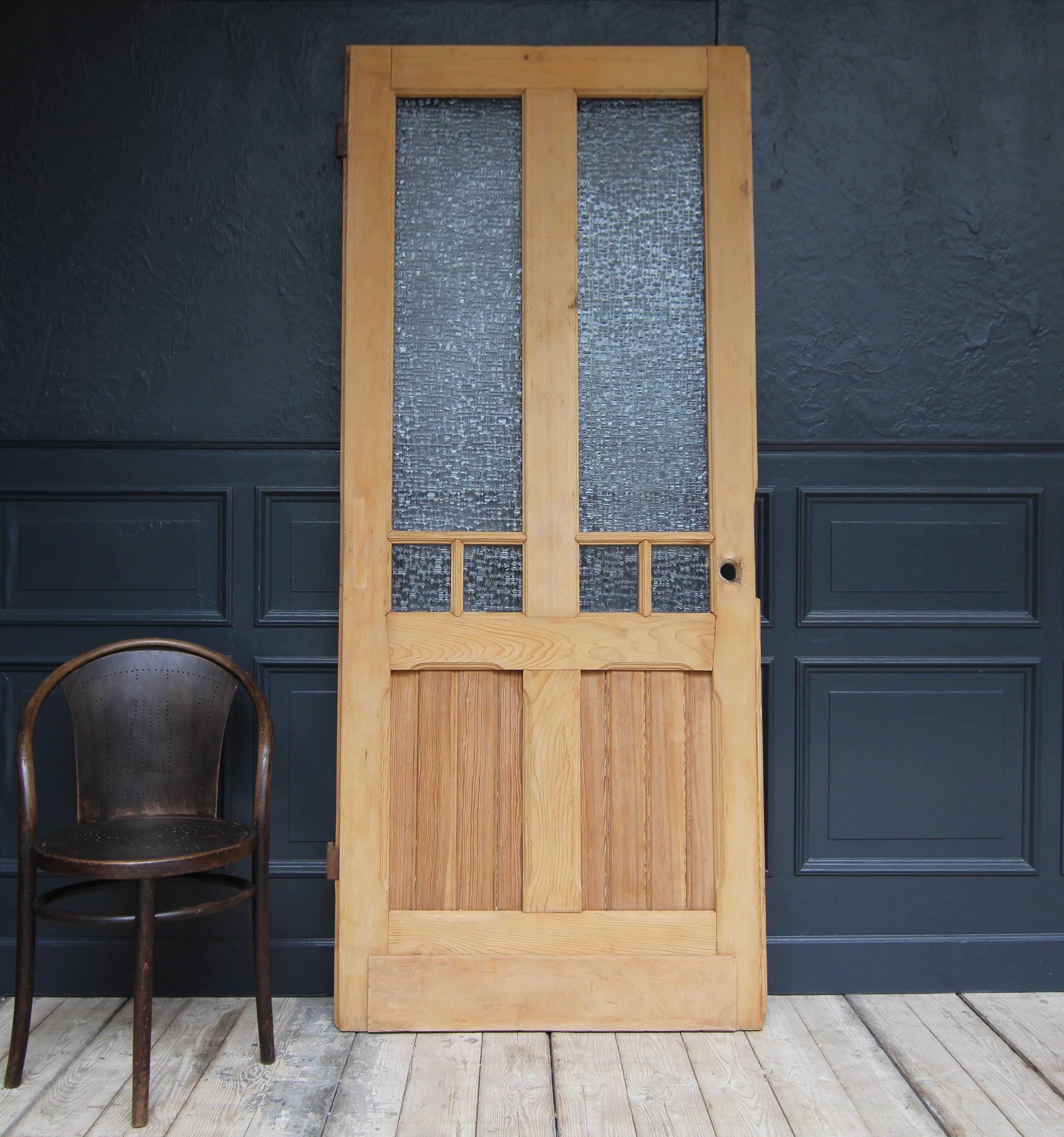 A Art Nouveau door from the early 20th century. Solidly crafted in softwood. 

Frame and panelled construction with ribbed glass and large iron fittings.

Dimensions: 
222 cm high / 87.40 inch high,
94 cm wide / 37,00 inch wide,
3.5 cm thick / 1.37