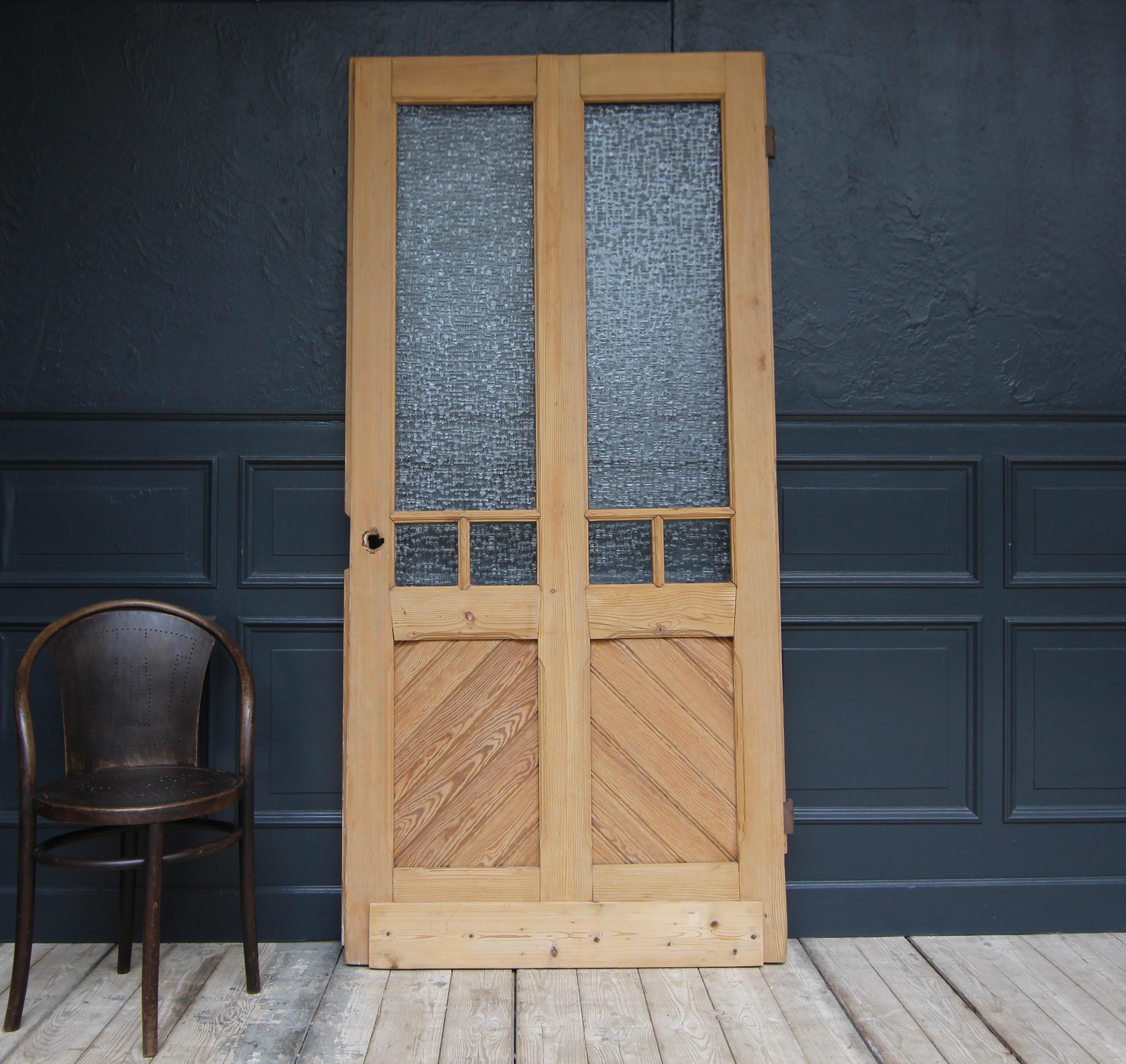 A Art Nouveau door from the early 20th century. Solidly crafted in softwood. 

Frame and panelled construction with ribbed glass and large iron fittings.

Dimensions: 
220 cm high / 86.61 inch high,
104 cm wide / 40.94 inch wide,
3.5 cm deep / 1.37