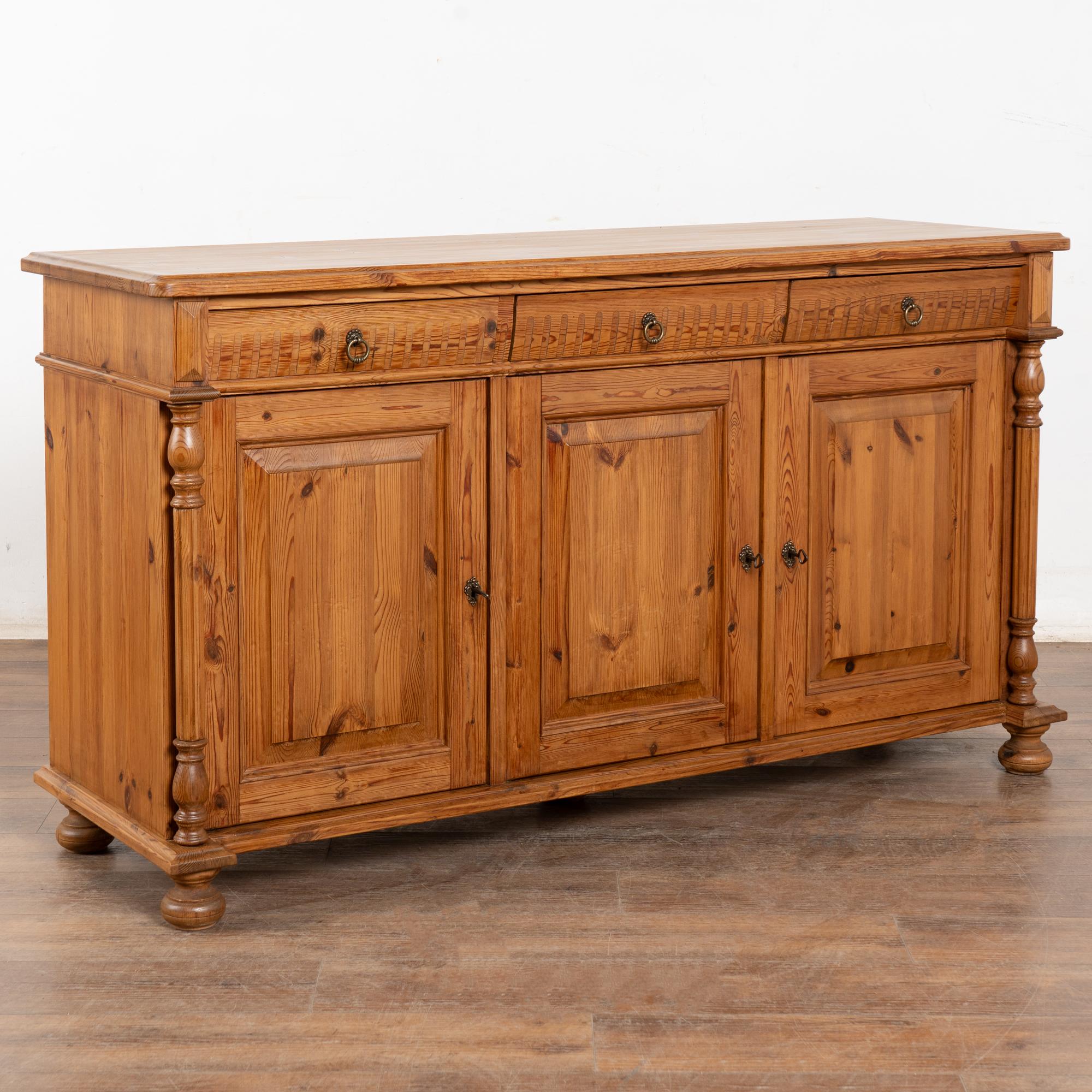 Credenza in pino danese con tradizionali intagli scanalati nei cassetti, colonne tornite che fiancheggiano i lati e sollevate su piedini a bussola.
Restaurato, solido, forte e pronto all'uso. La finitura a cera esalta il calore del pino naturale.