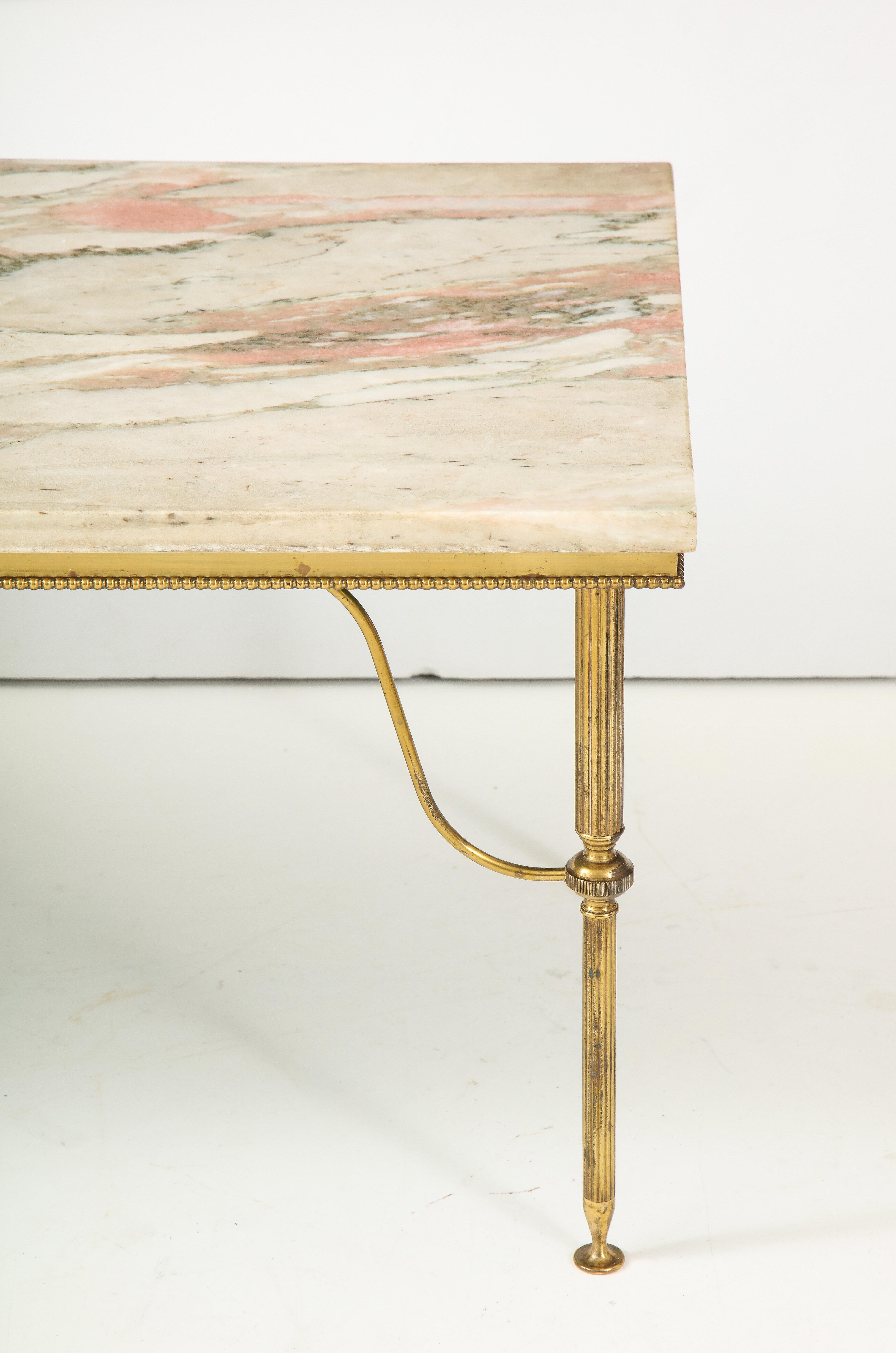 Early 20th century pink marble cocktail table. Beautifully simple brass base with claw feet. Marble is inset and removable for transport with holes to align marble properly on the piece, very rare detail for this era.