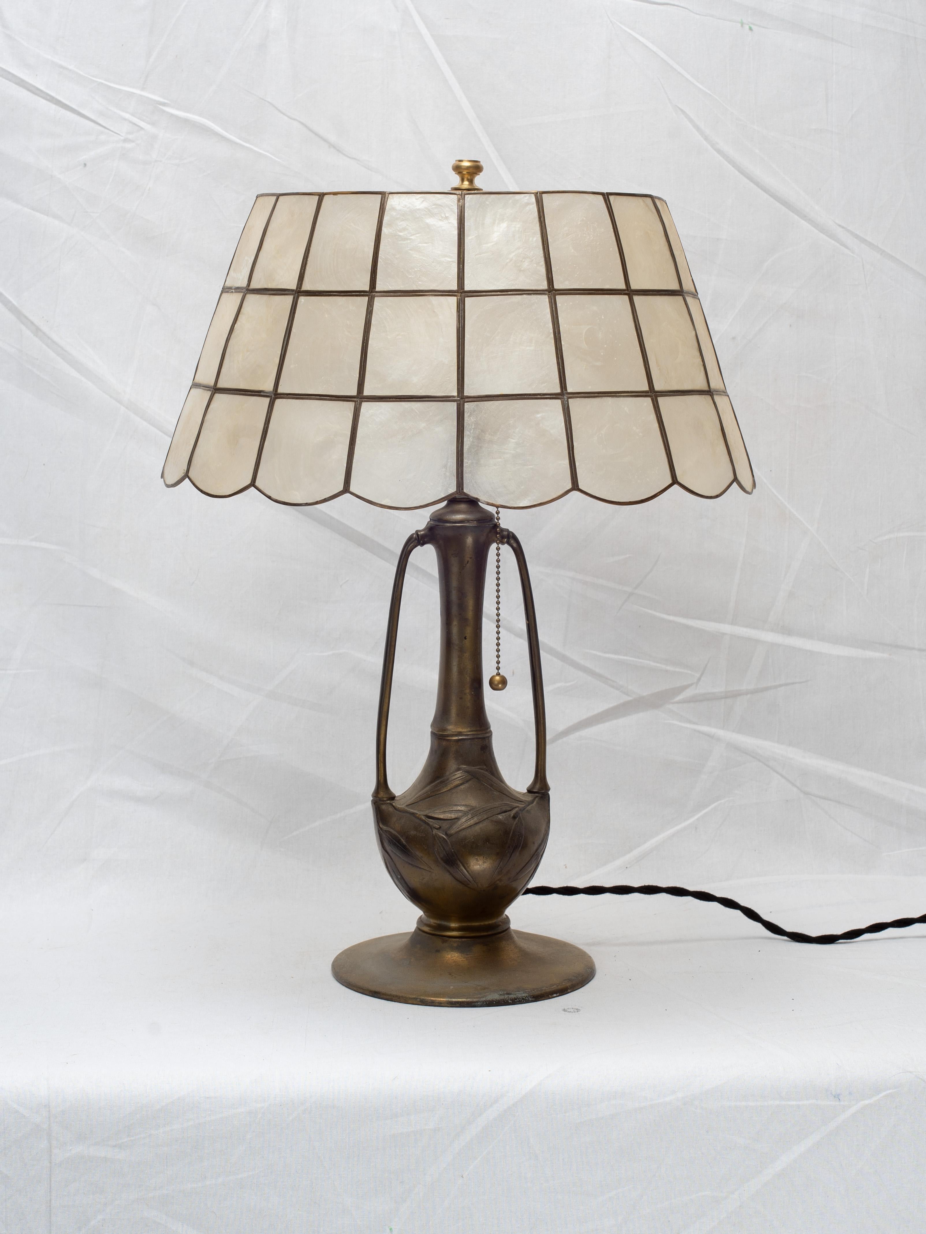 Exceptional early American art nouveau Pittsburgh table lamp, featuring olive leaves in the bronzed base and fitted with vintage scalloped brass and Capiz shell shade.

The Capiz shell shade is relatively newer, likely from the 1970s to 1980s, and