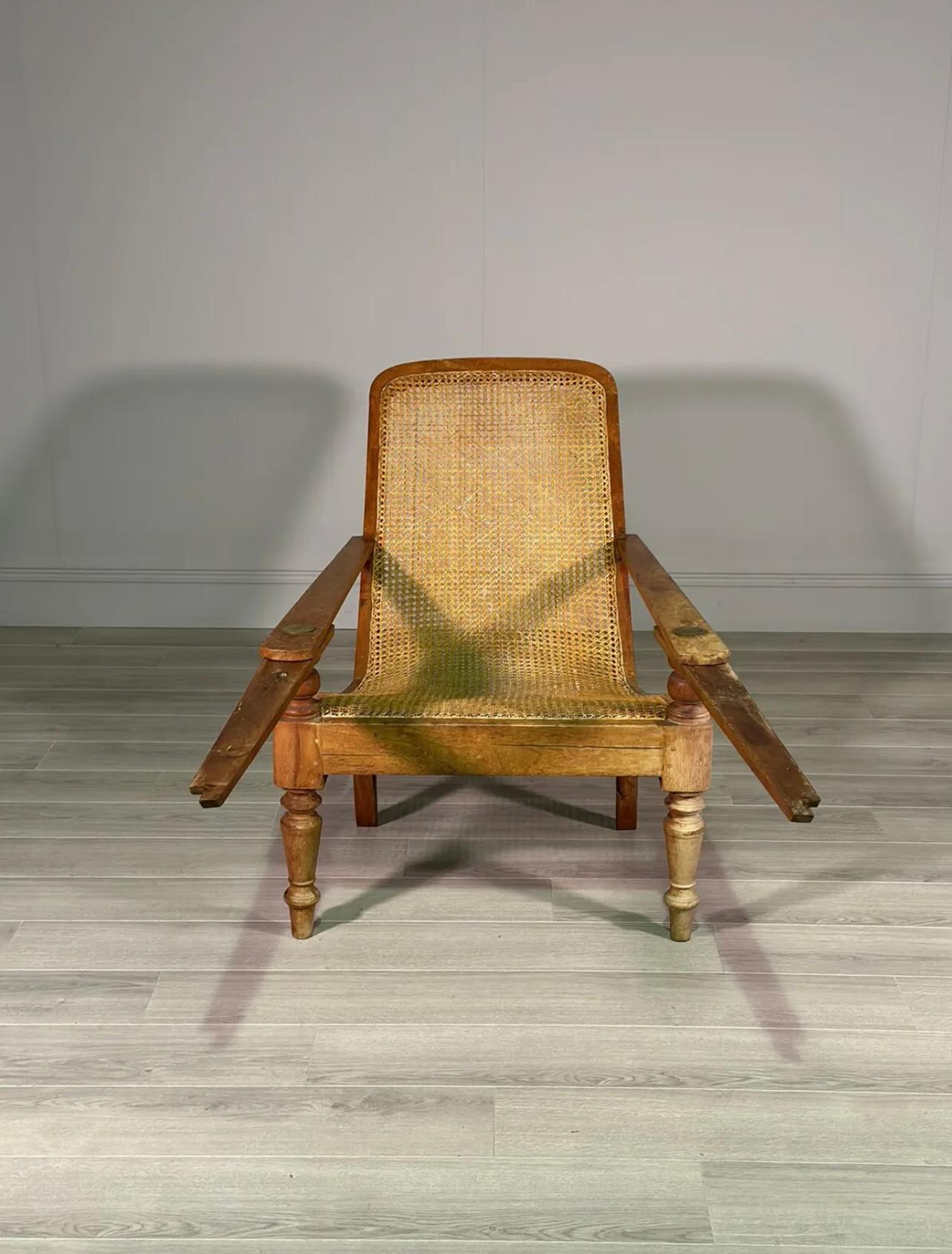 An early 20th century plantation chair, the chair is made from birch wood with a cane seat which has one very small repair. The chair is large in size with extra long leg rests and is a fine example in very good condition.

Seat Height - 43.5cm
Seat