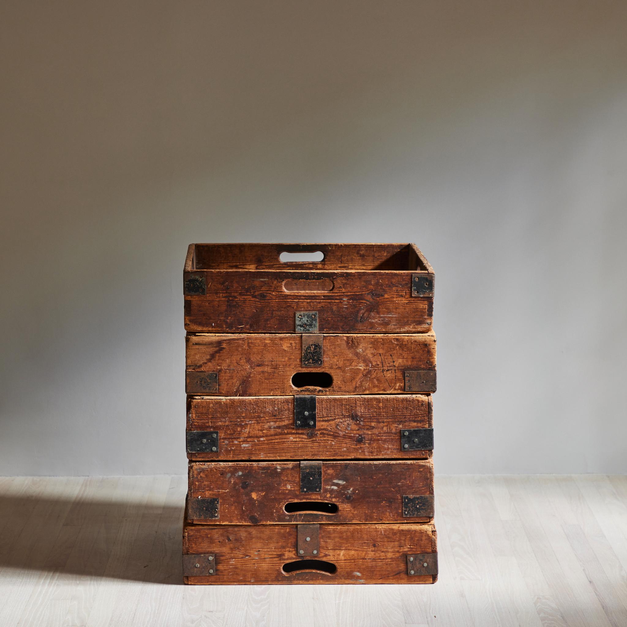 Set of four early 20th-century French wooden planter boxes, originally used to transport pottery. With utilitarian accents and a rustic patina, these industrial wooden boxes bring the feeling of a studio into any space. Can be stacked or displayed