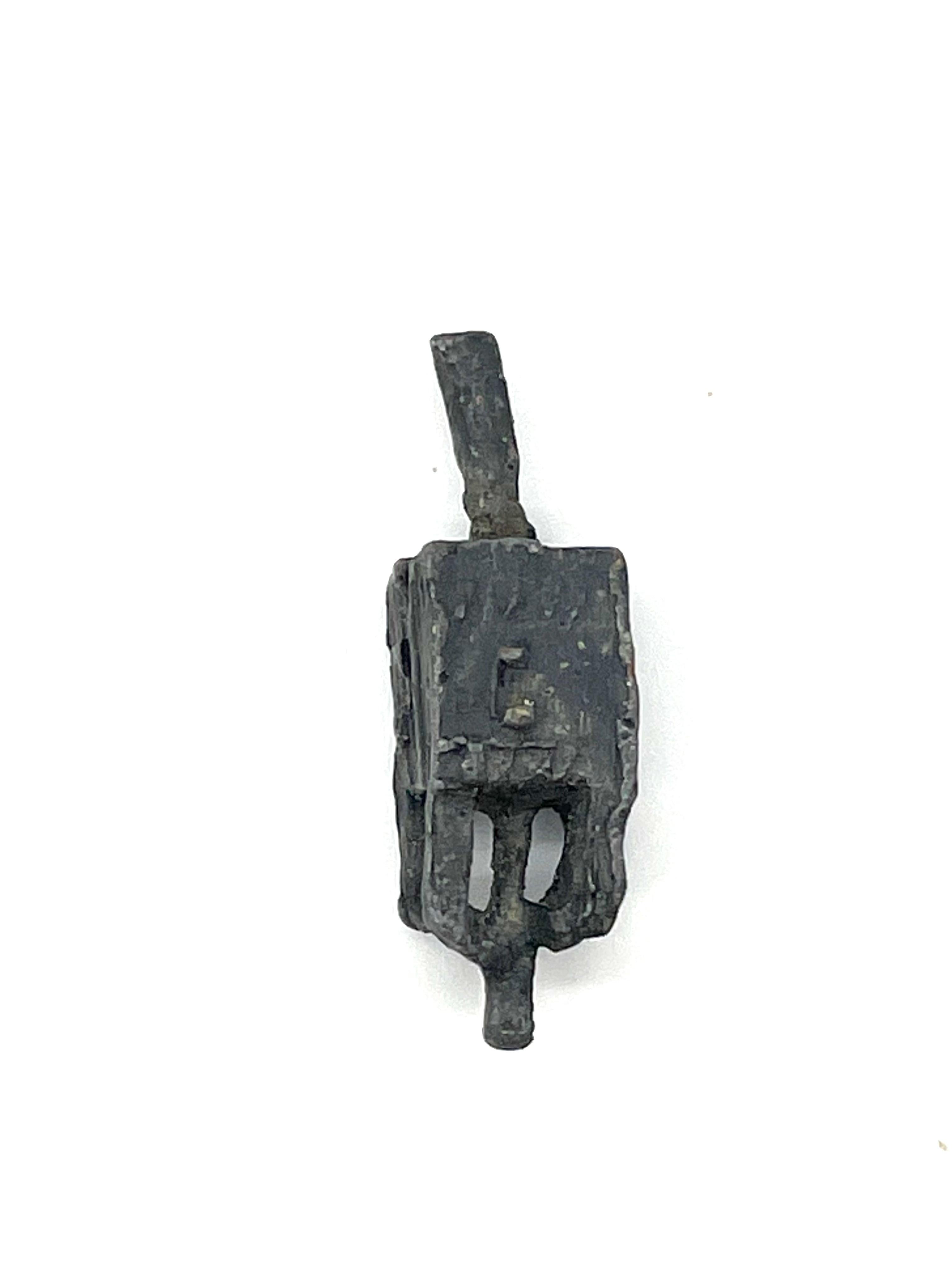 Cast lead Hanukkah dreidel, Poland, circa 1900. Found unearthed after roadwork construction began on Zgierska street in the city of Lodz during the 1950s. Elongated shape with overlay of dense grey cast. Distinctly bold Hebrew letters on each flank
