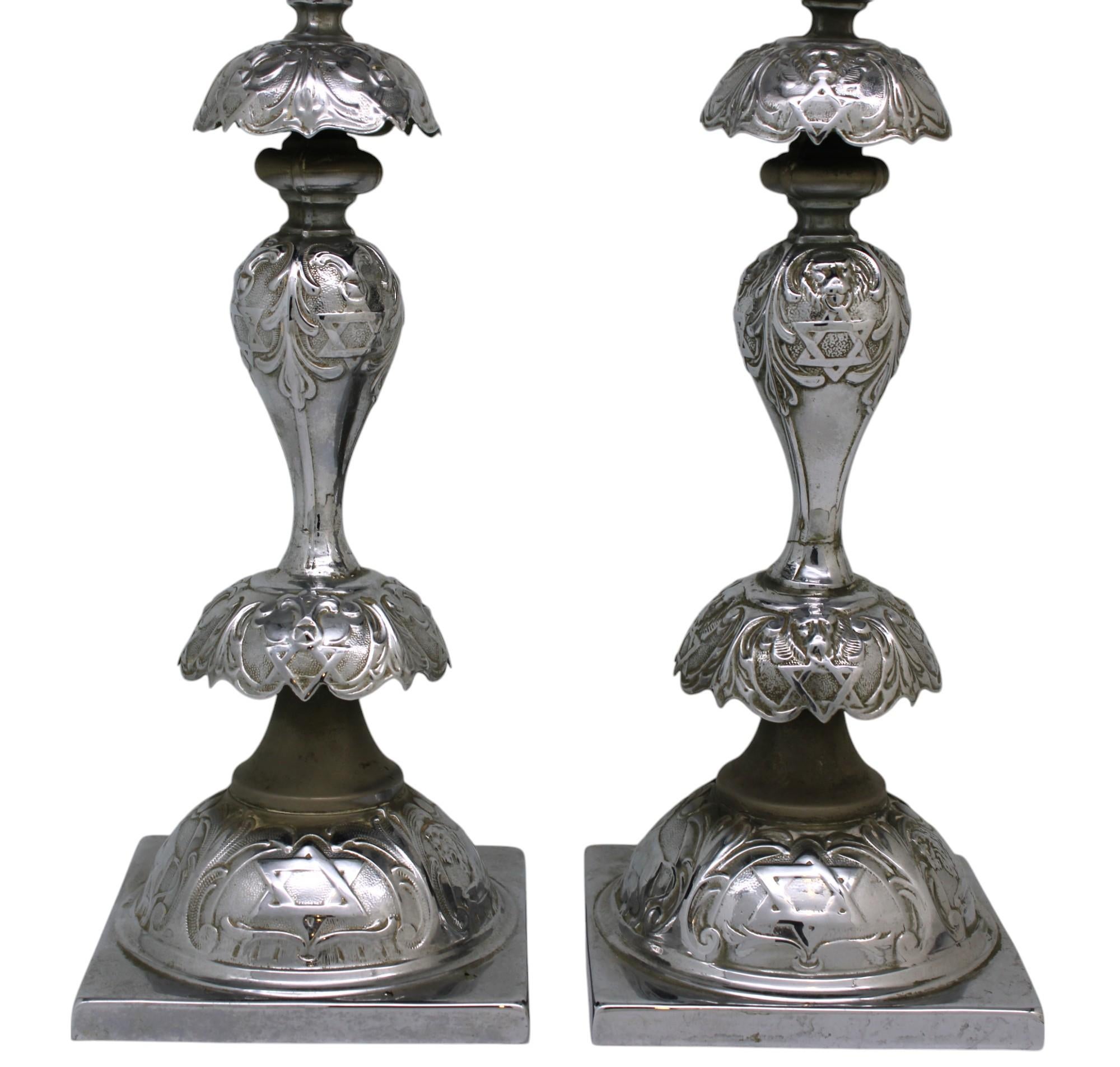 Rara coppia di candelieri da Shabbat in ottone argentato, realizzati a Varsavia, in Polonia, nel 1908. Questi candelieri da Shabbat abbinati, con fiori, leoni e stelle di David, sono il risultato della produzione in catena di montaggio che abbondava