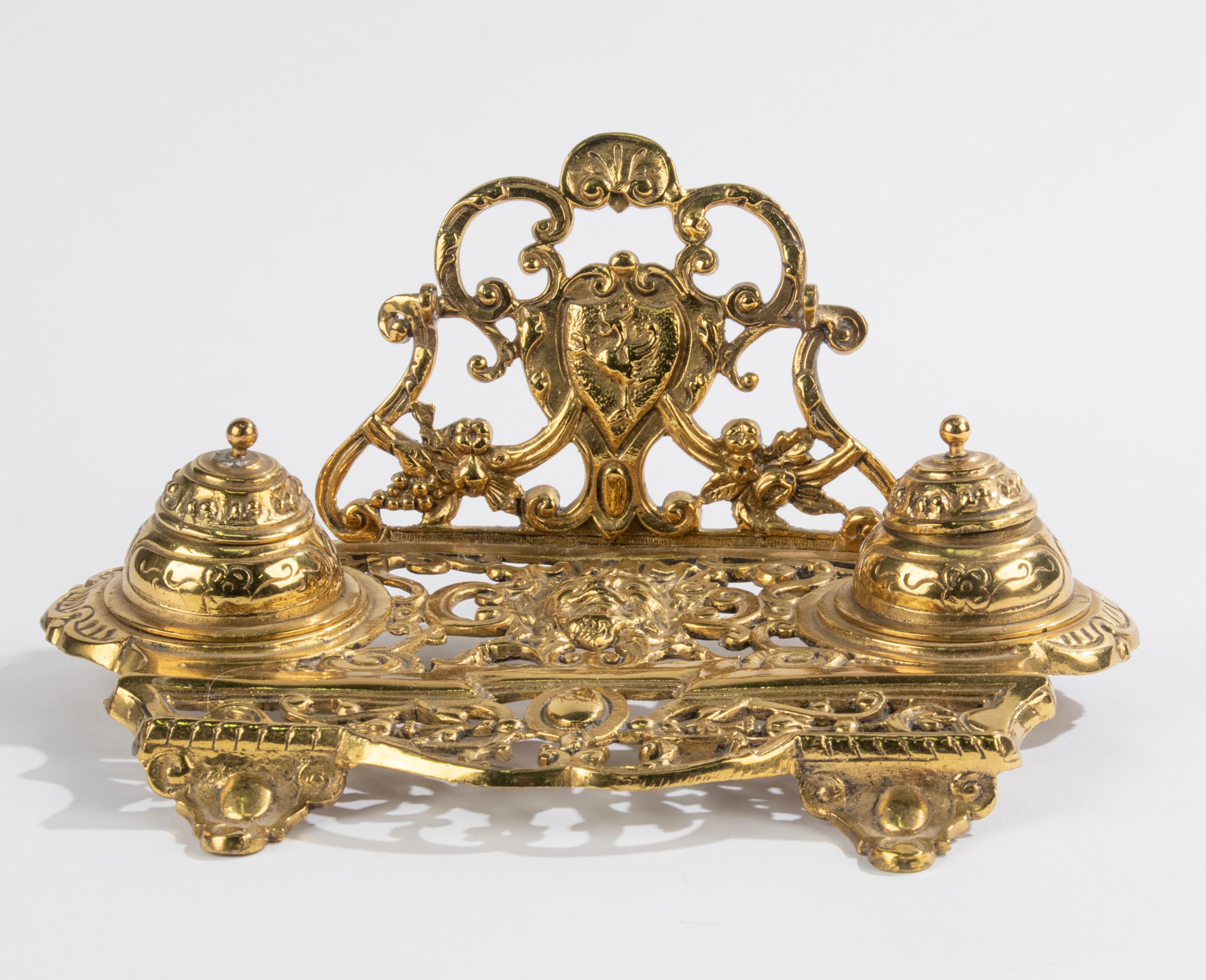 An antique ink stand, made of polished brass, completely in Renaissance style, with richly pieced scroll motifs. The inkwell has two removable ink wells. The upright support has a penholder. Made in France, 1900-1910
Dimensions: 12 (h) x 26 x 18