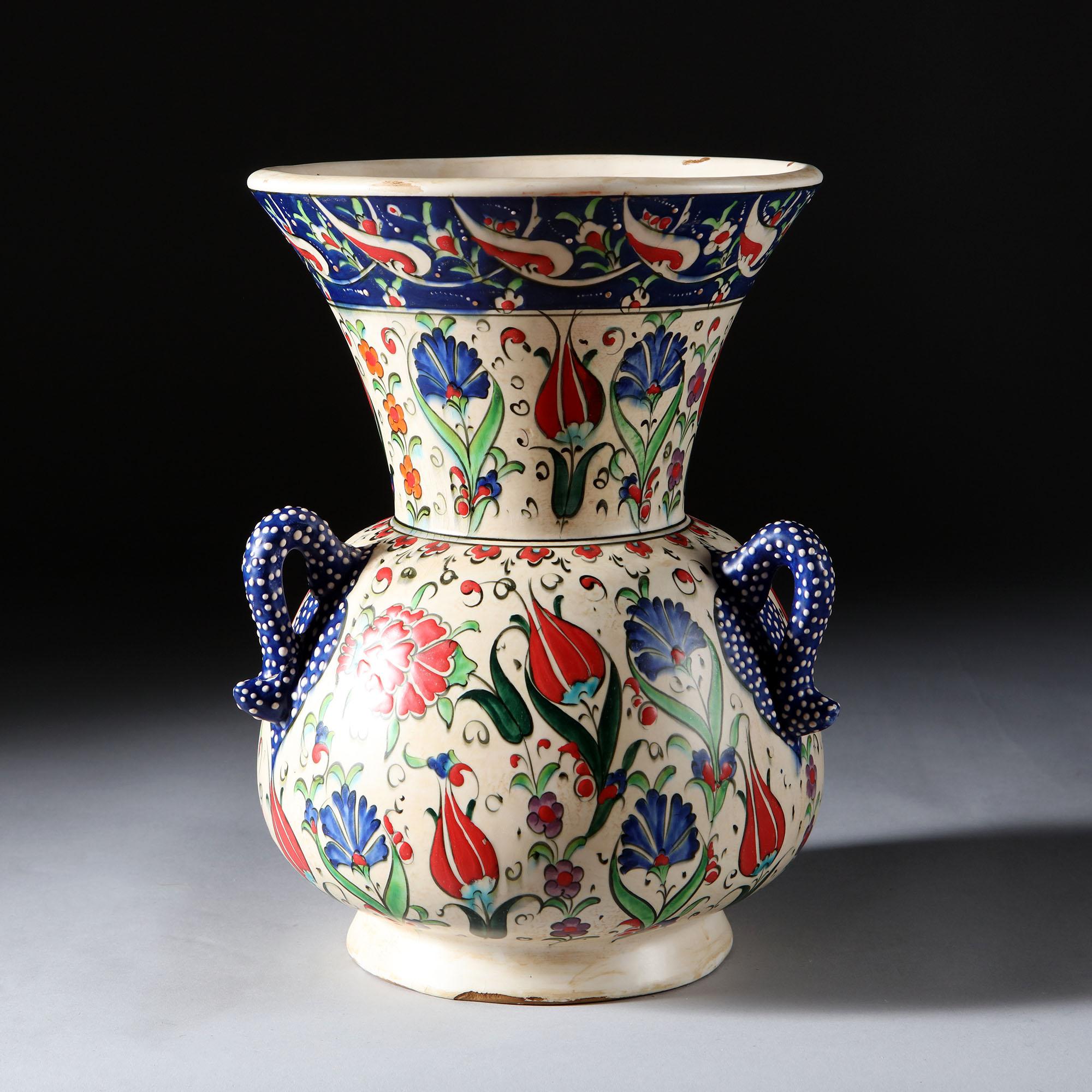 An early 20th century Islamic Mosque lamp in the Iznik style, painted in vivid colors with decoration of tulips and carnations, with three blue loop handles with white spots, now converted as a lamp.

Currently wired for the UK. Please enquire for