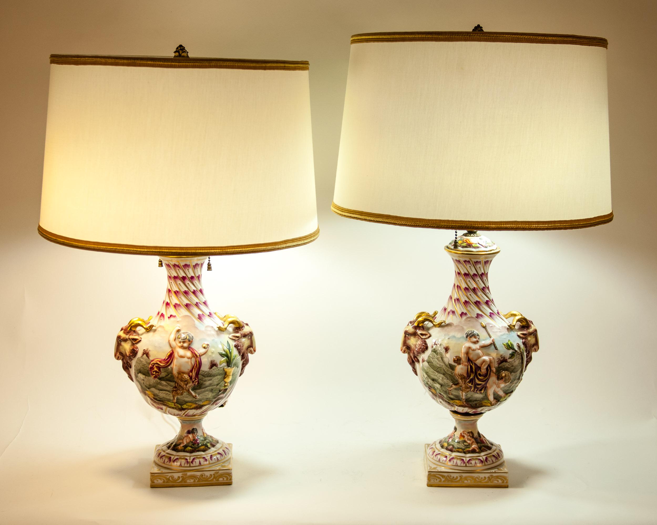 Early 20th century porcelain pair of table lamp with adjustable finial. Each lamp is in great vintage working condition. Maker's mark undersigned. Each lamp measure about 23.5 inches high x 9 inches diameter. Each lamp come with a round silk