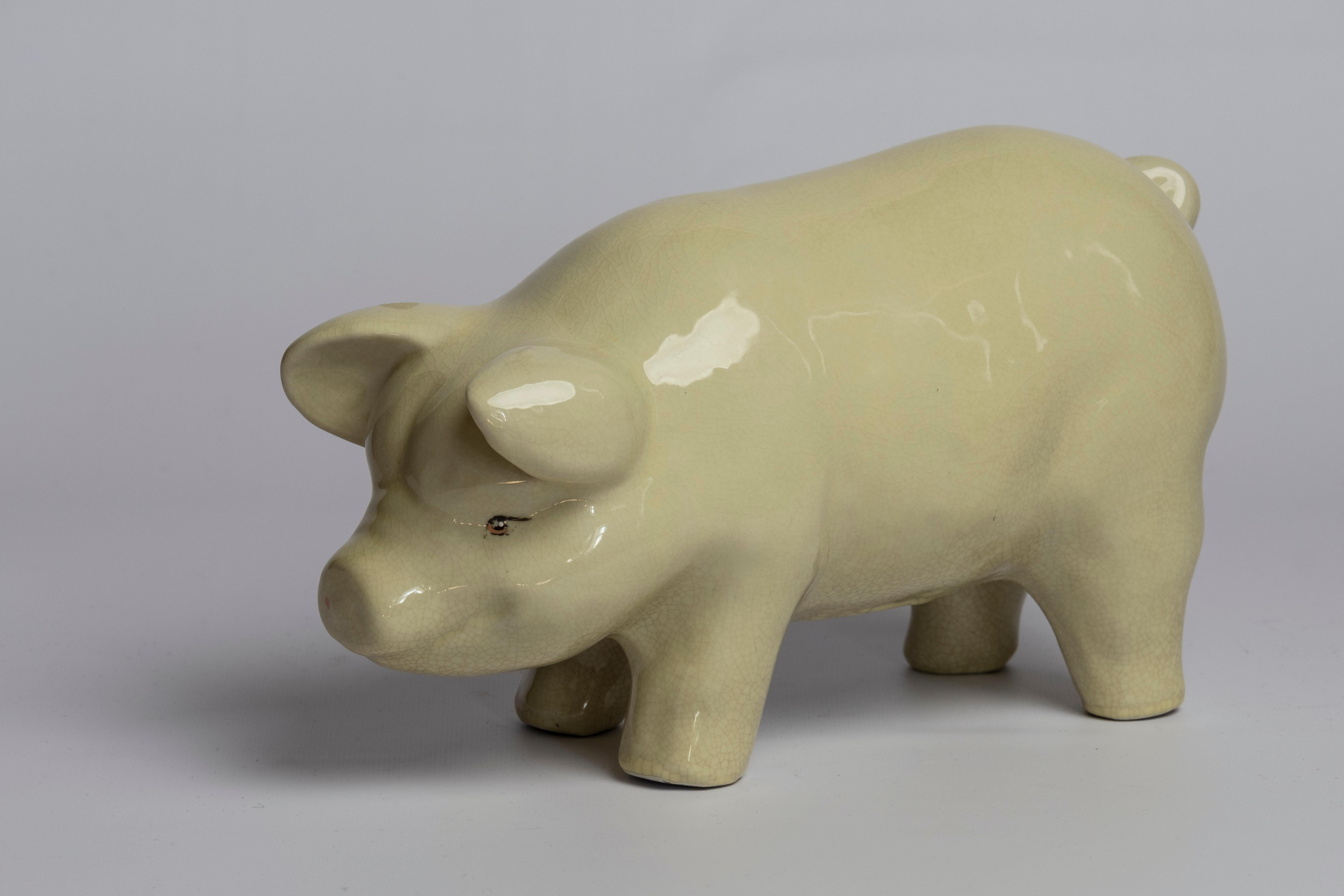 Early 20th century porcelain pig. Beautifully patinated and crackled creamy white glaze. Quite possibly an old piggy bank, fed through bottom since slot at the top missing.