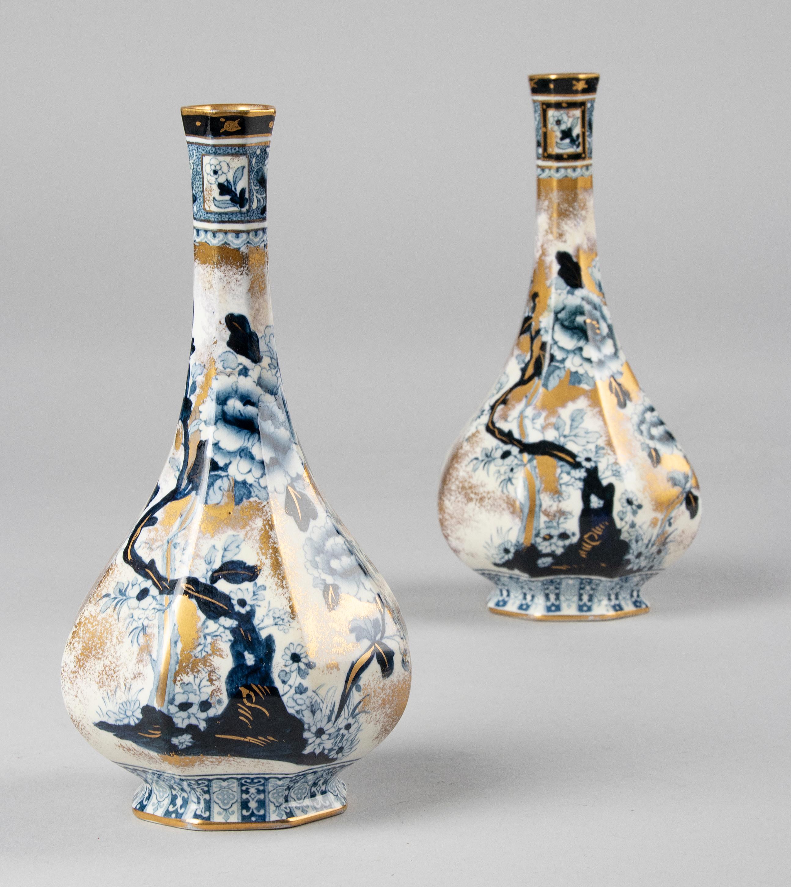 A beautiful pair of antique vases from the English brand Keeling & Co, Chusan Losol Ware. The vases have a beautiful design with a narrow tapering neck and angular shapes. The vases are decorated with cobalt blue flowers and gold colored accents.