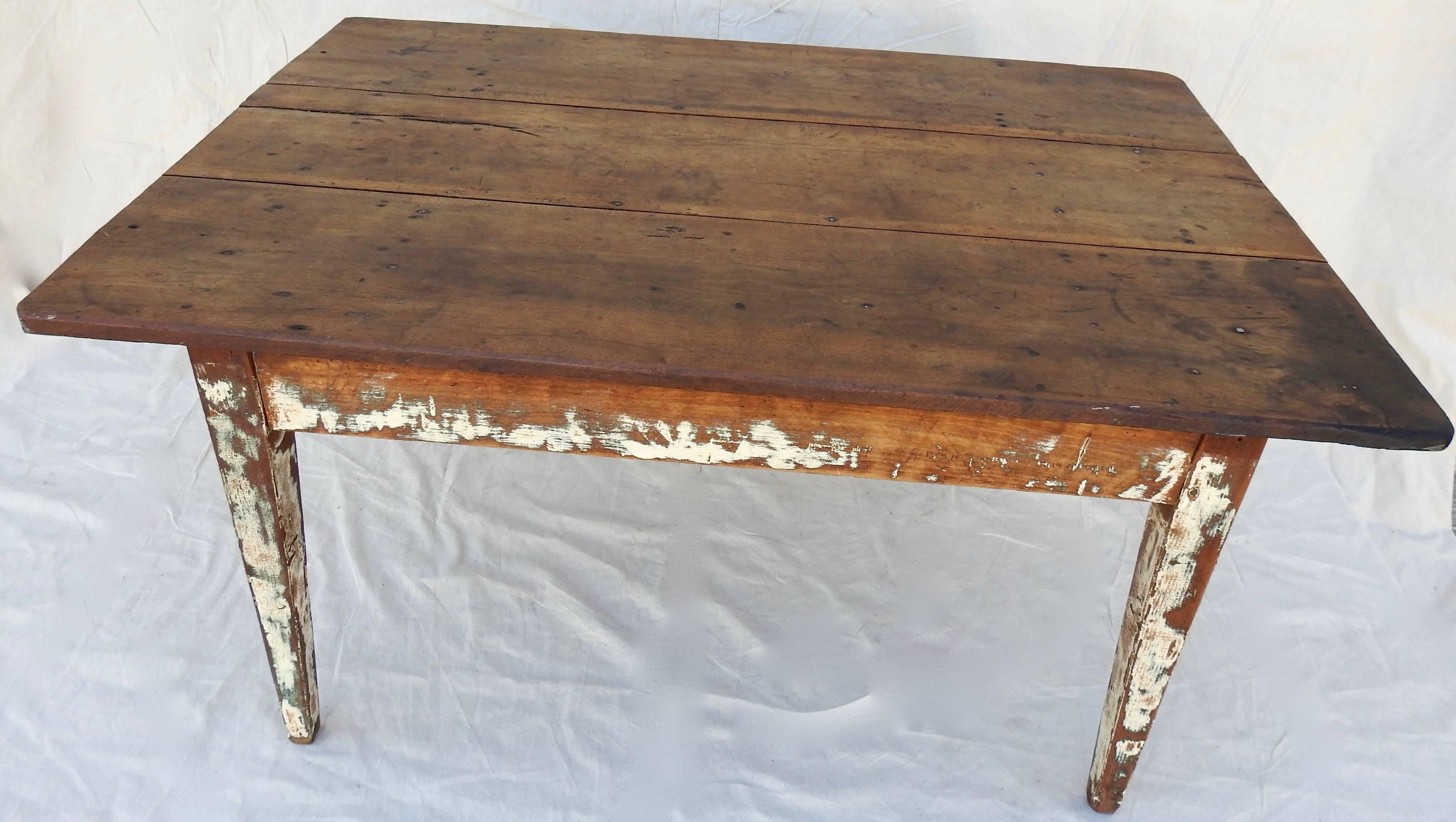 Chippy white paint on the legs and sides of this walnut farm table will be perfect for your farmhouse style! The simple, tapered legs support the smooth walnut top with rounded edges. The worn finish will give it a warm feel in your home. Square