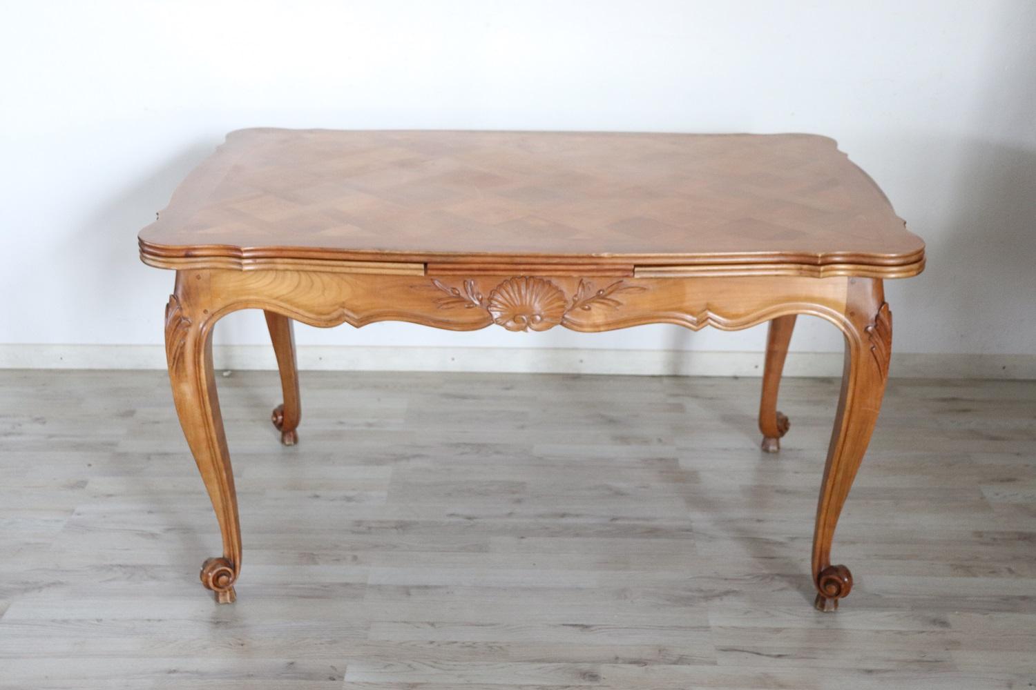 Beautiful french provencal dining room table, 1930s in solid cherry wood. Characterized by beautiful wavy legs with carved decorations on the classic-style band, the top has a beautiful marquetry decoration. Easily extends to the sides. The maximum