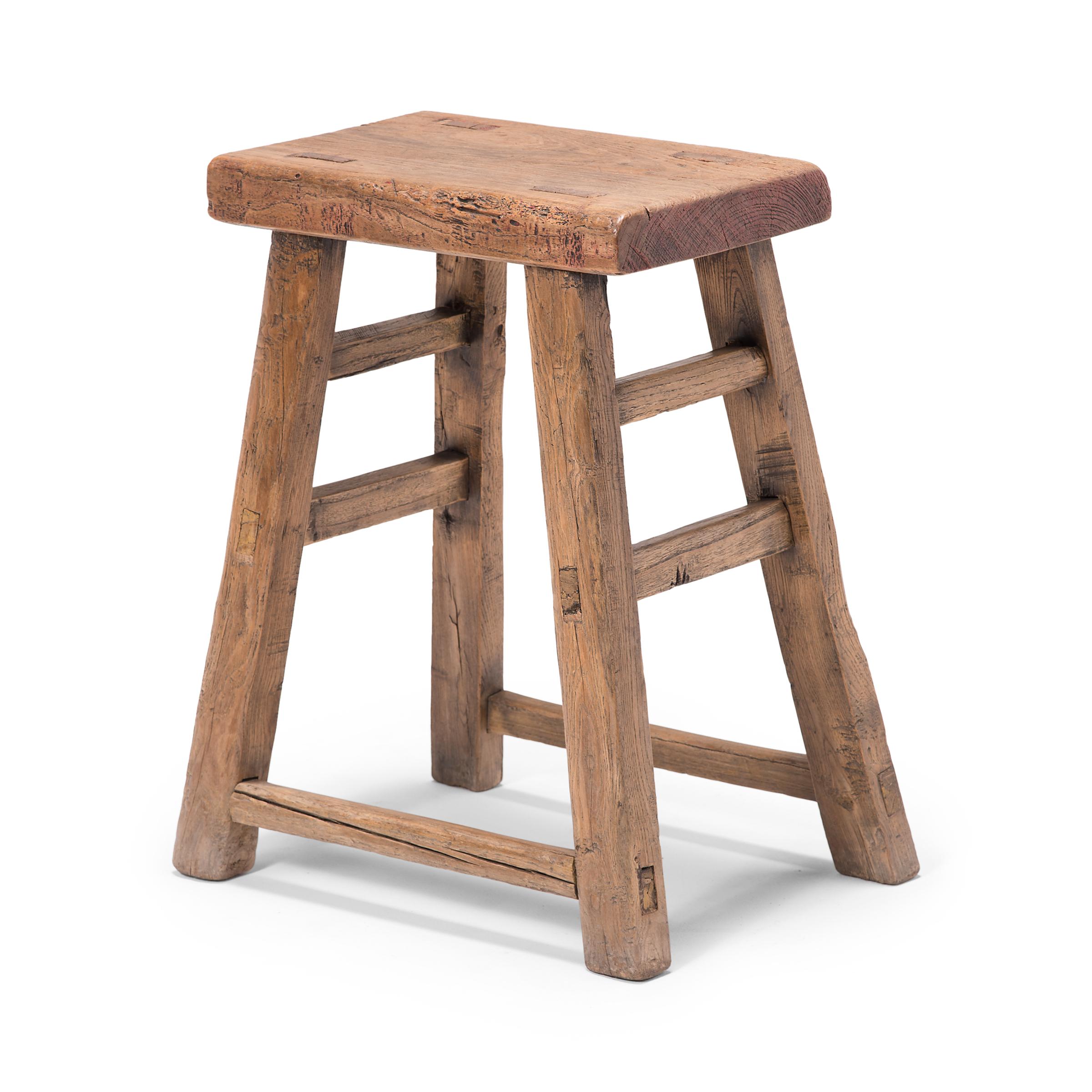 This early 20th century stool from China's Hebei province features a square seat supported by splayed legs, linked with simple double stretcher bars. Constructed with mortise-and-tenon joinery techniques, without the use of nails or screws, the