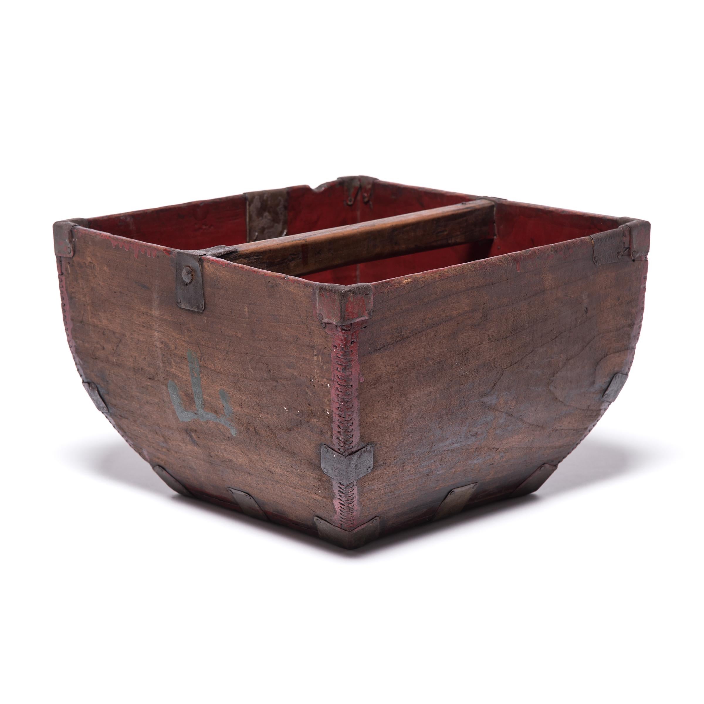 This rustic container was made over a hundred years ago to measure and hold a dou of rice, an ancient Chinese measurement. Handcrafted with dovetail joints, the vessel has gracefully swelling sides and an arched handle, burnished from years of use.