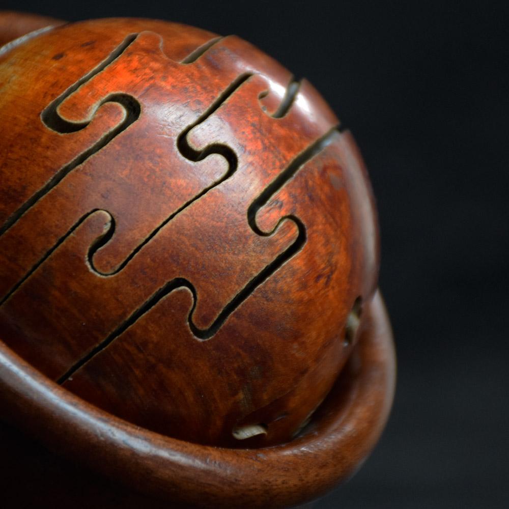 Early 20th century puzzle ball 
We are proud to offer an unusually difficult to solve puzzle ball, encased in its own hand carved wooden standing bowl. This puzzle ball in made from fine wooden sections that have been carved to peice together