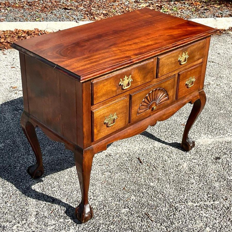 Romantic Queen Anne style Lowboy adorned with traditional drop handles and a central shell carving. Fantastic whimsical addition to any space that needs an element of old world class. Acquired from a Palm Beach estate.